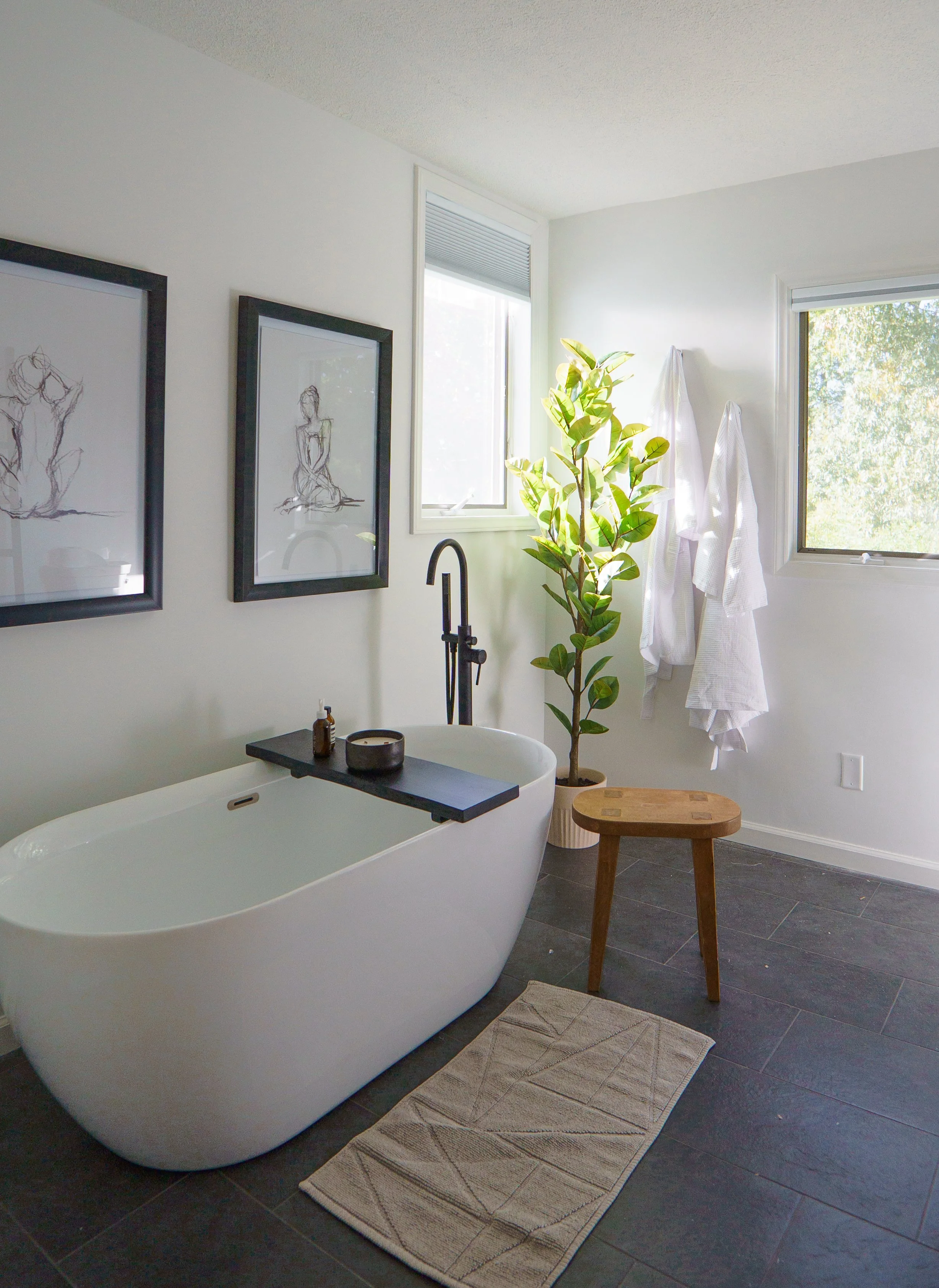 Photo of large freestanding soaking tub in a sun-drenched luxurious bathroom