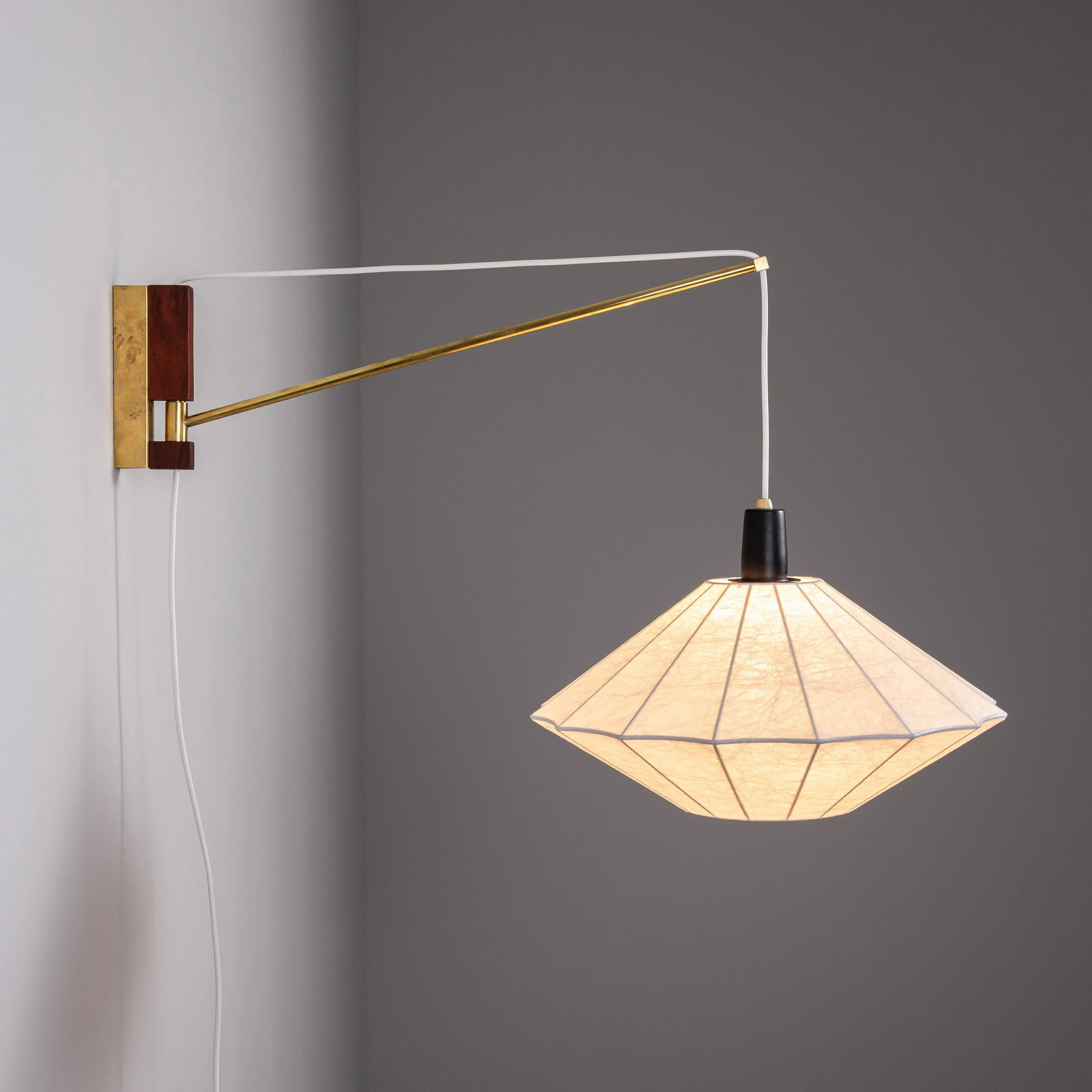 Suspendable wall lamp with brass details
