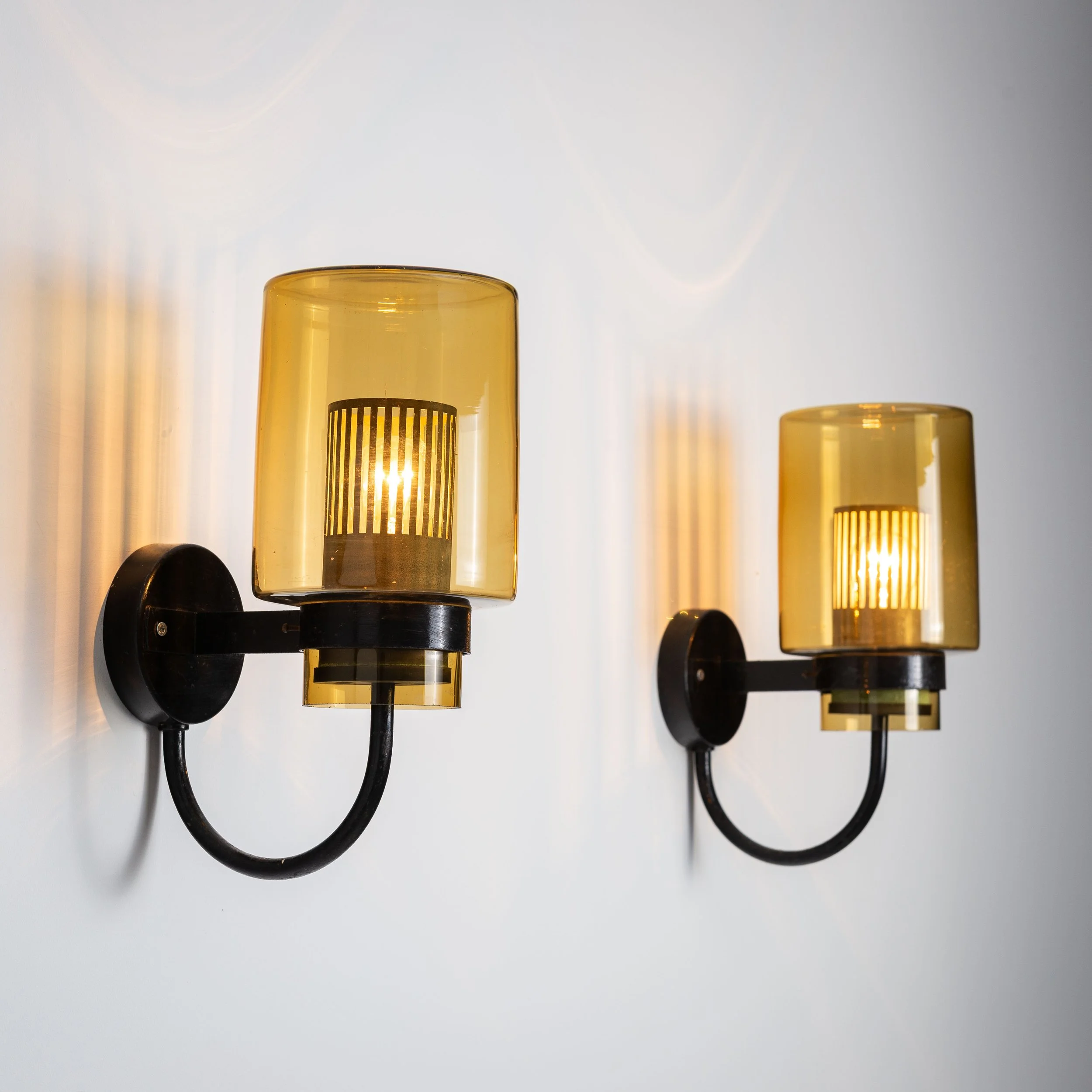 Pair of black metal wall lamps with yellow shades