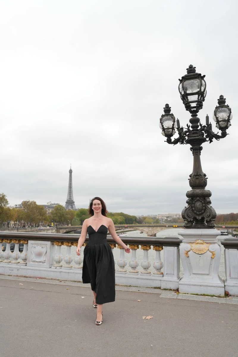Sales messaging strategist Chelsea Quint walking a Paris bridge near the Eiffel Tower.
