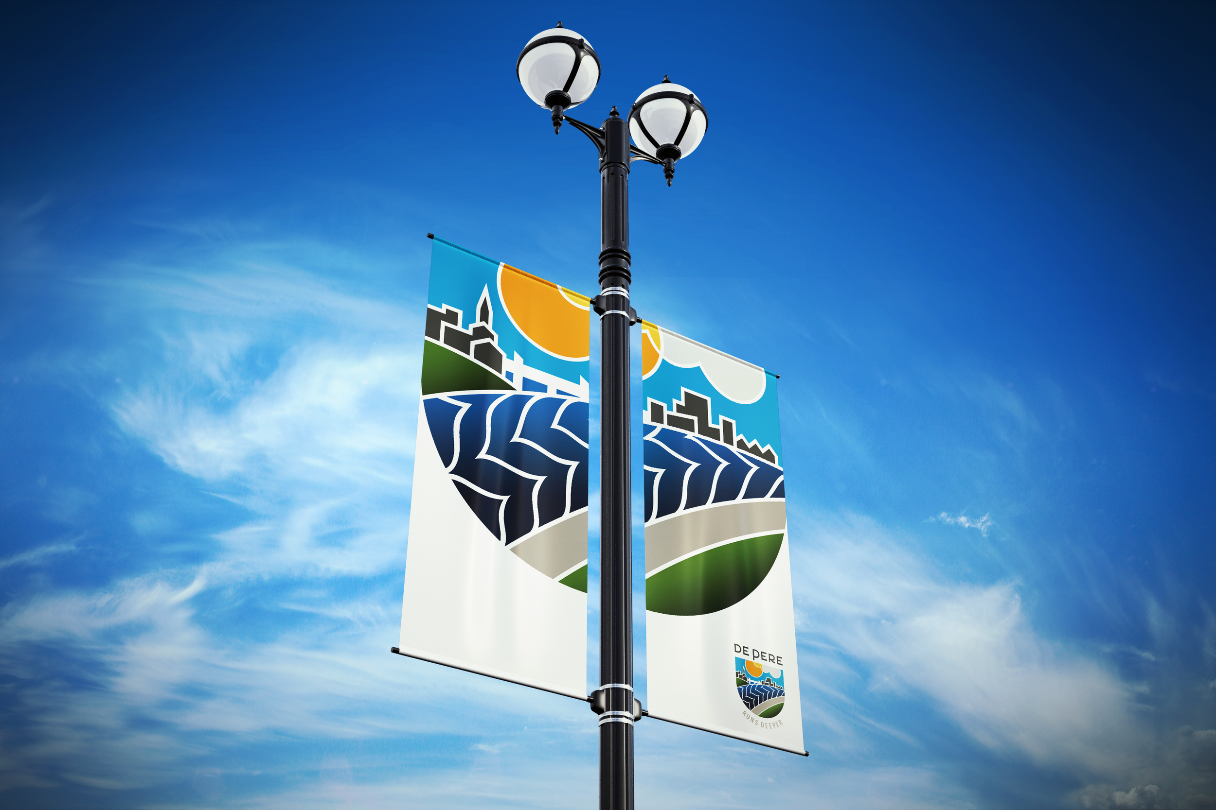 A street lamp with colorful banners attached, featuring abstract cityscape and natural landscape designs, set against a blue sky with wispy clouds.