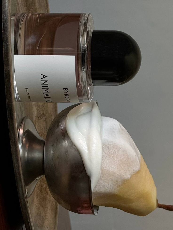 Un flocon de neige en gelée, une cuillère avec de la crème fouettée ou glace, un pot de parfum ou crème sous un couvercle noir et un flacon de parfum ou cosmétique.