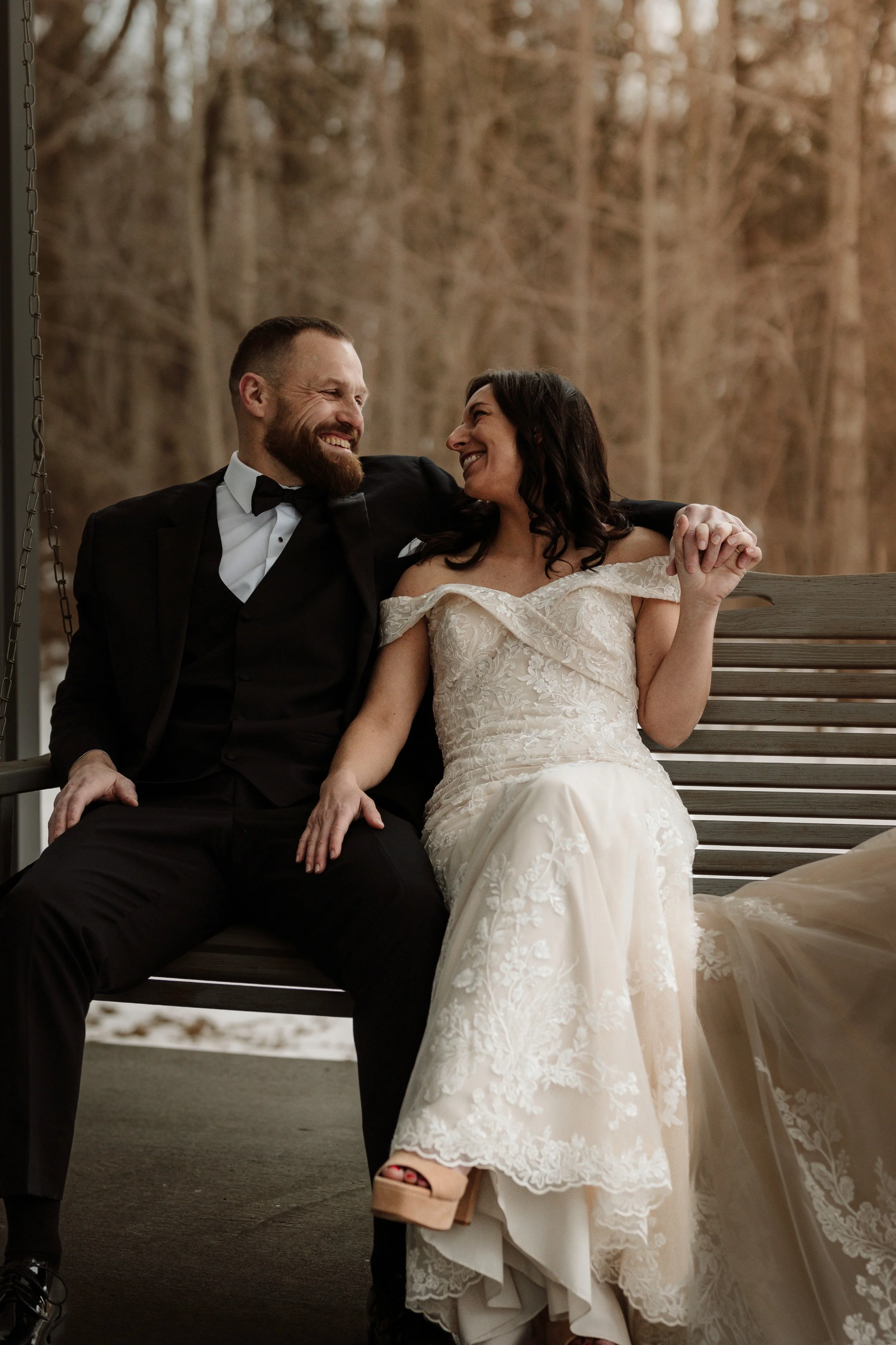 Wedding portrait of a couple sharing a loving gaze on a porch swing at an outdoor venue in Kentucky.