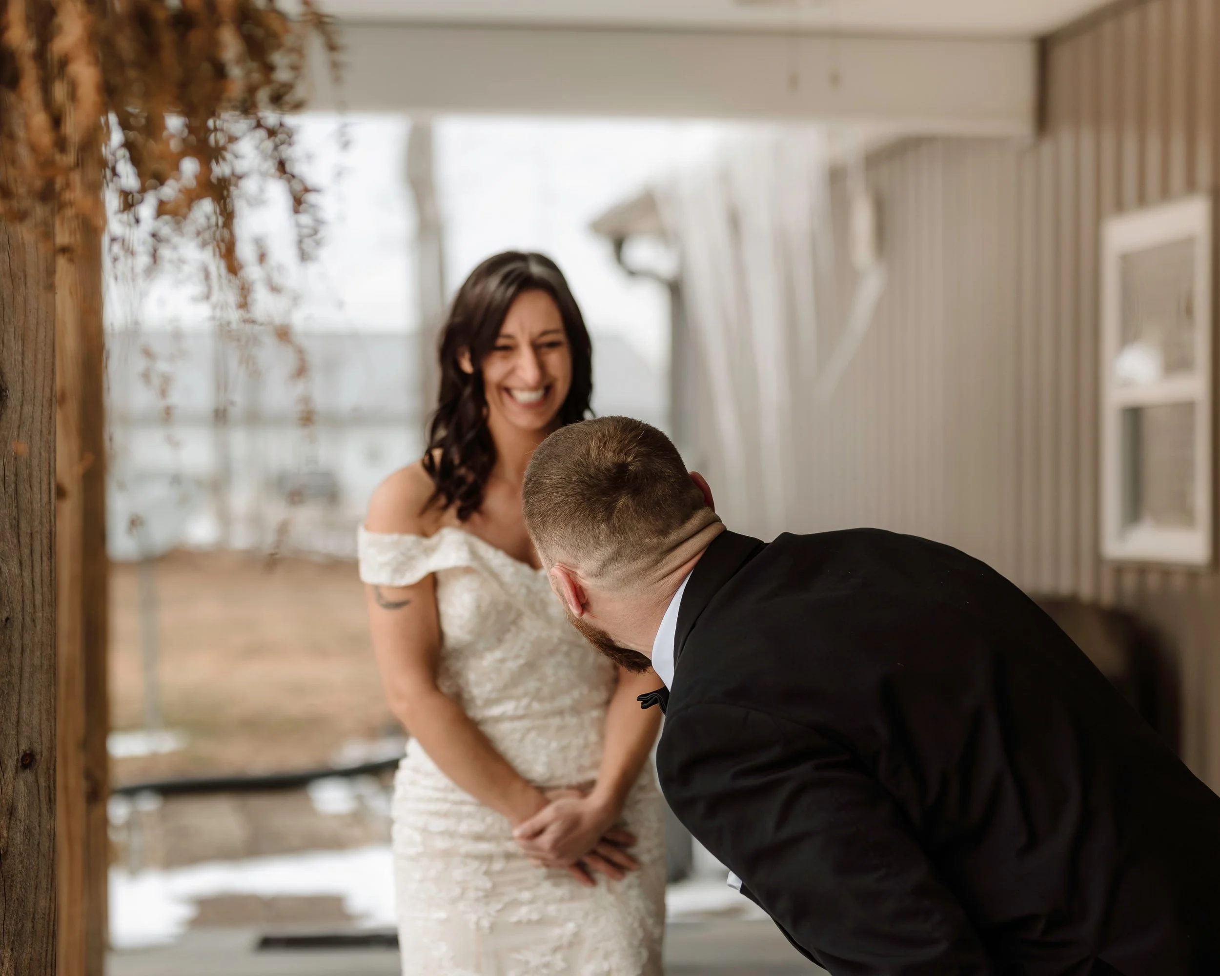 Intimate wedding photography of a happy bride smiling at her groom during a tender outdoor moment.