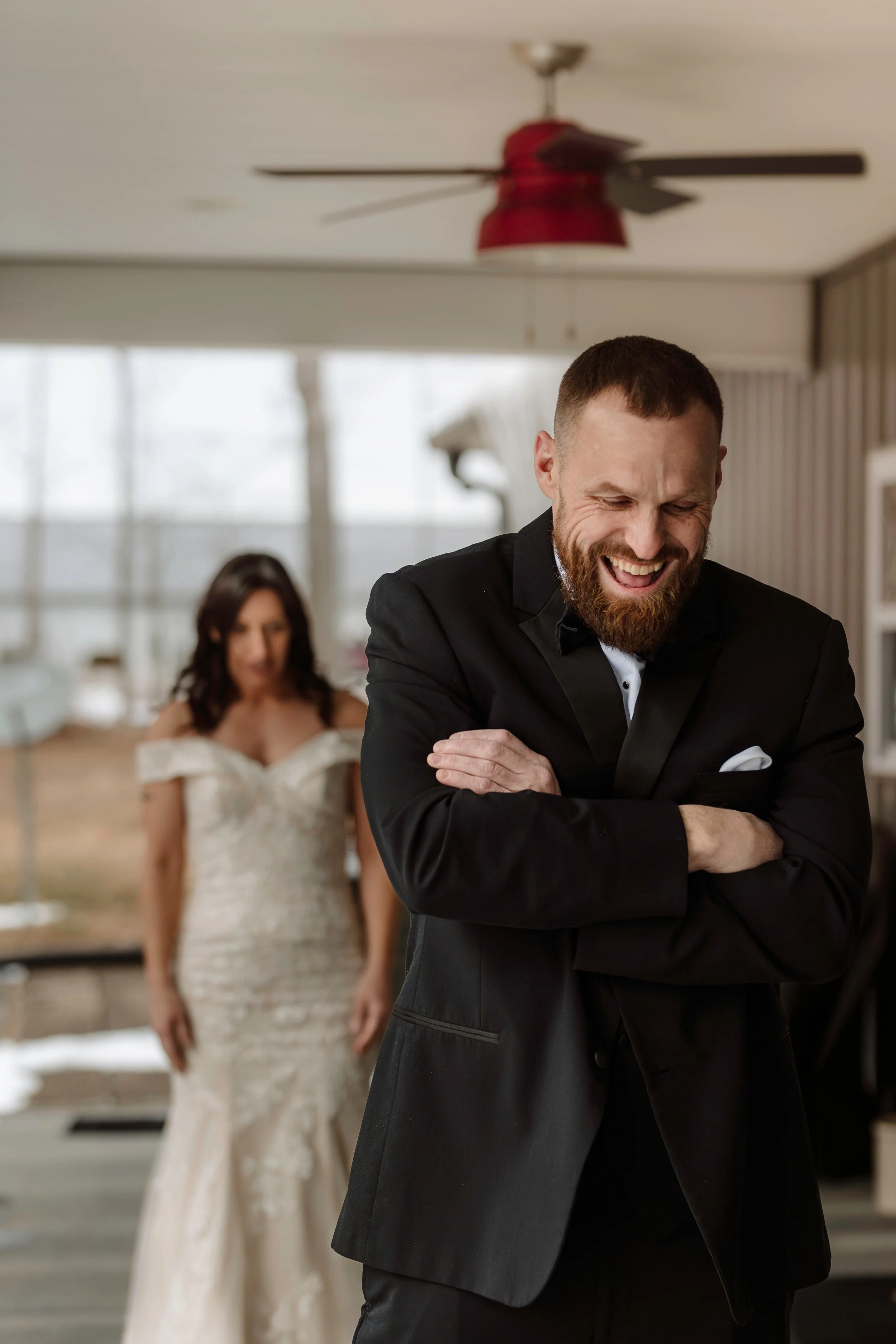 Heartfelt first look wedding photo of a groom reacting emotionally as he sees his bride for the first time.
