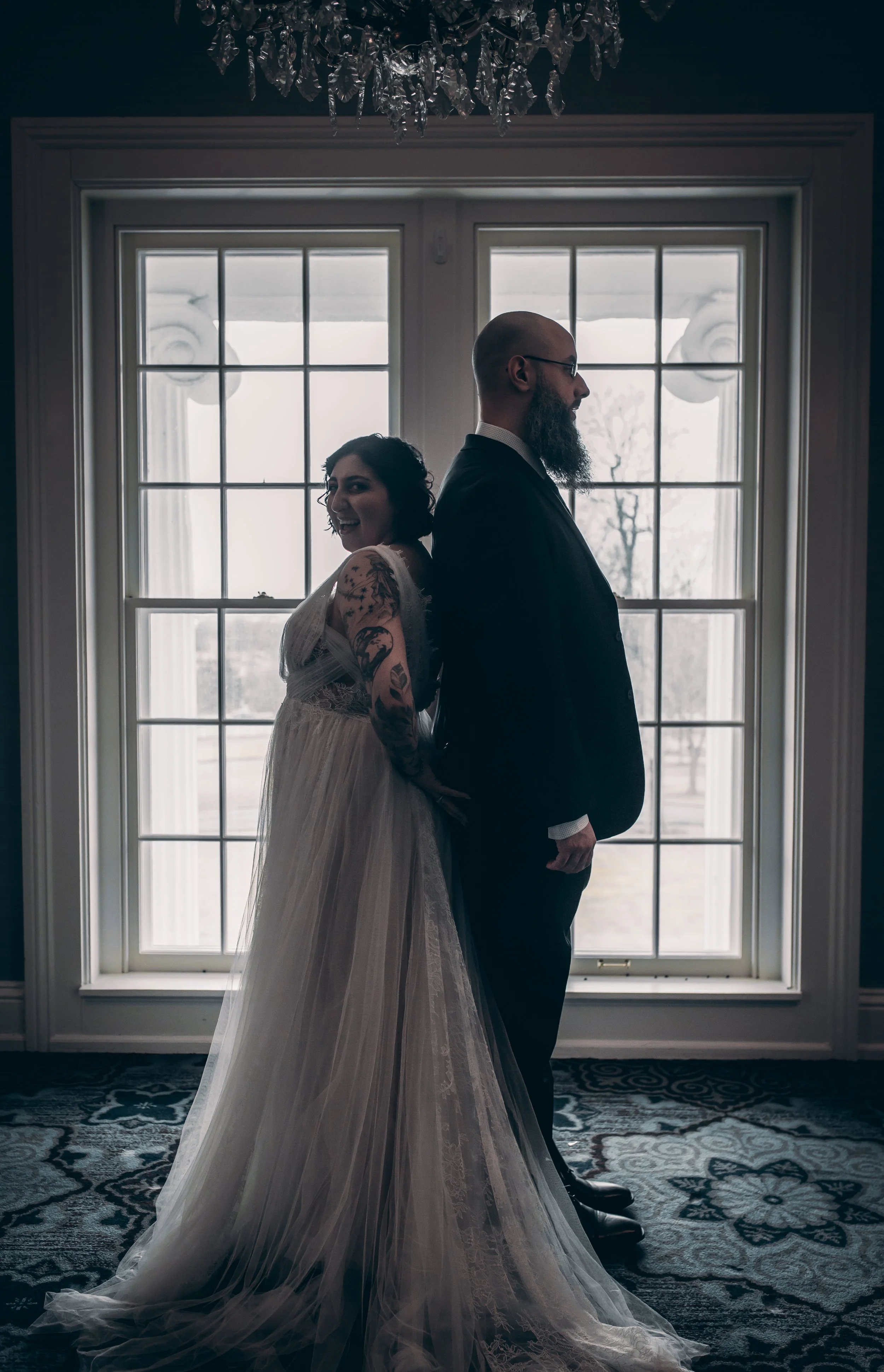 A bride and groom stand in silhouette, framed by a large, bright window at their historic Lexington, KY wedding.