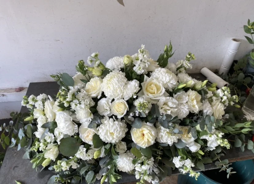 Elegant white and green funeral casket spray with seasonal flowers by Pash Flowers Melbourne