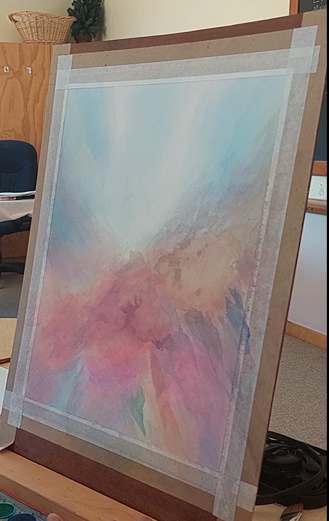 Abstract watercolor painting on an easel in a room with office furniture.