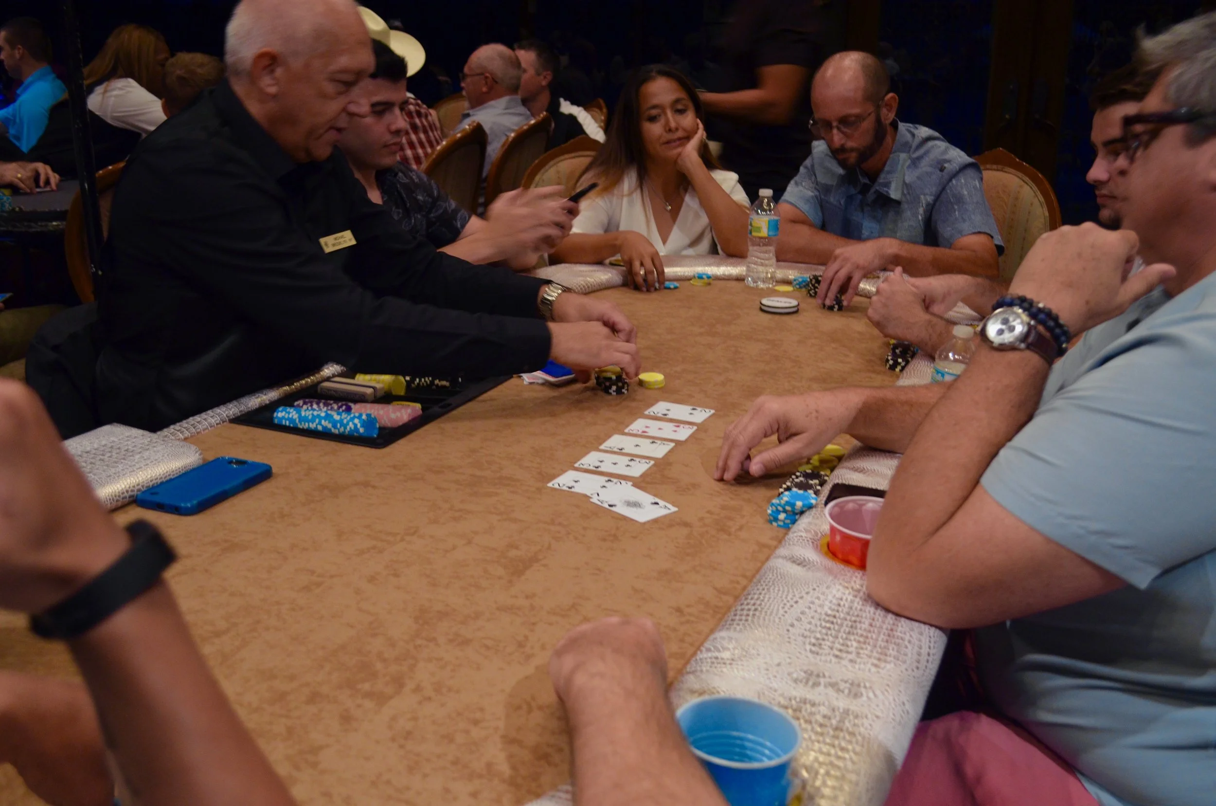 People playing poker at a casino table.