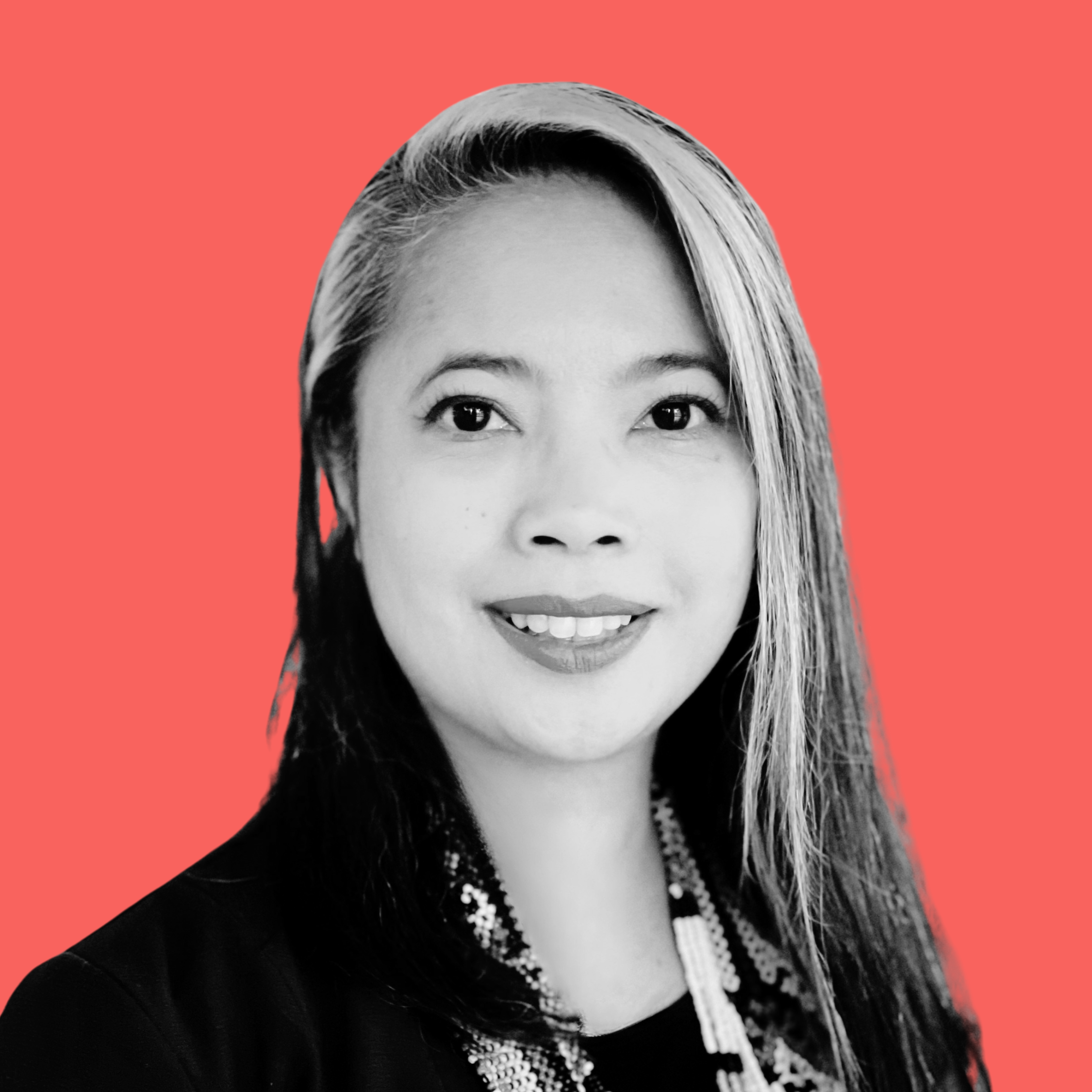 Black and white portrait of a smiling woman with long hair against a coral background.