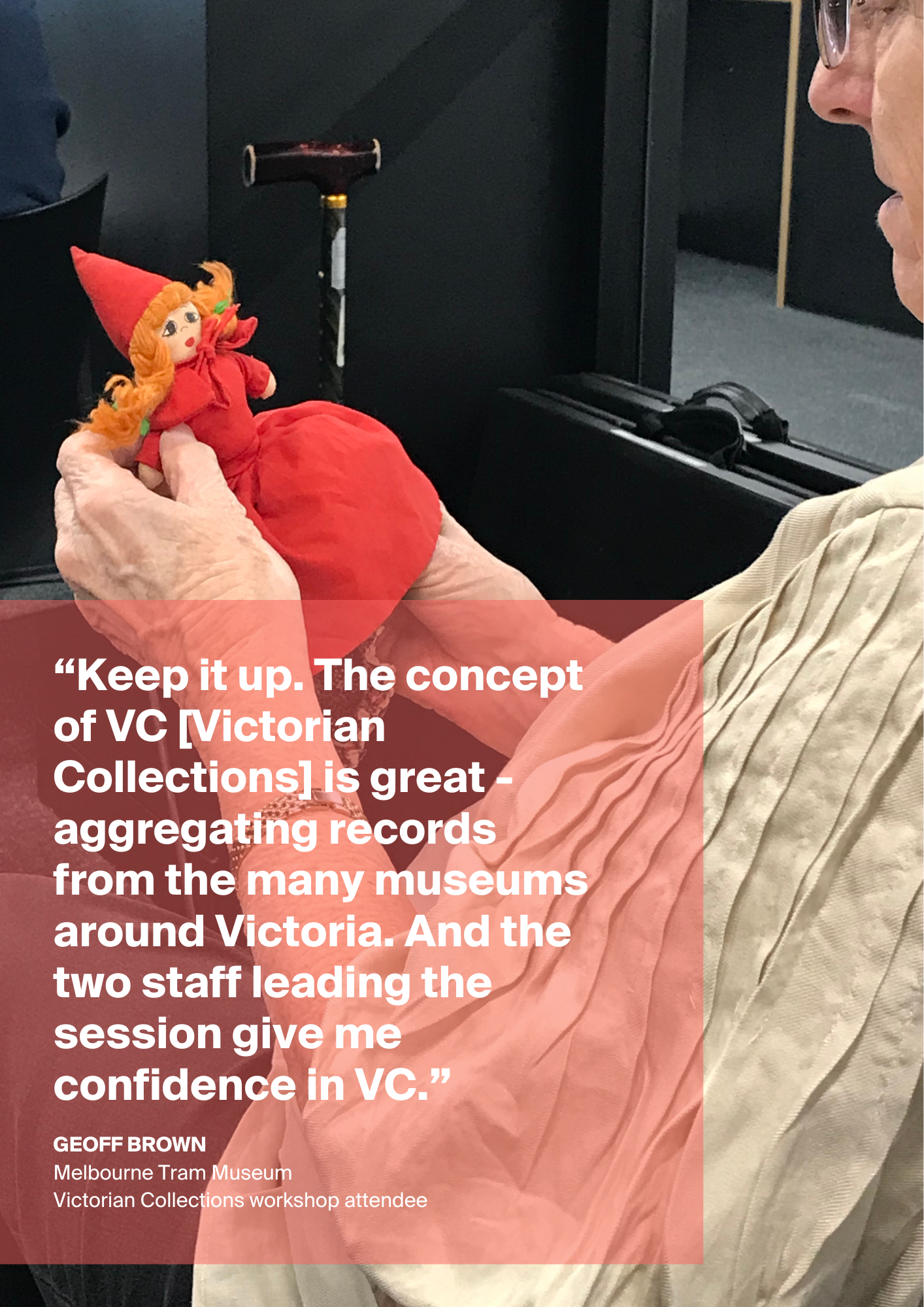  A person is sitting in a chair holding a doll wearing a red dress and hat. A quote in white text against a red, transparent background is overlaying the image.