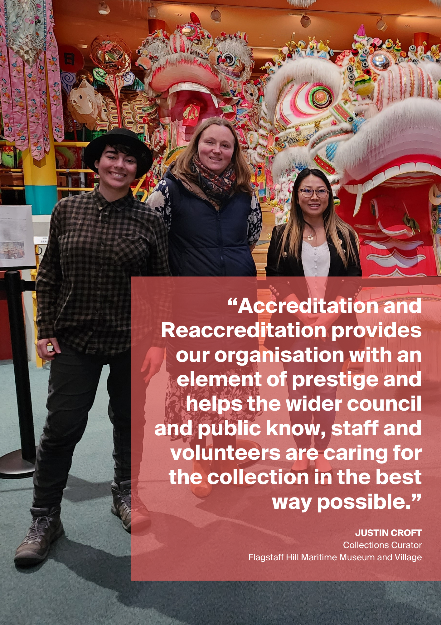 A group of people standing in front of a dragon. A quote in white text against a red, transparent background is overlaying the image.