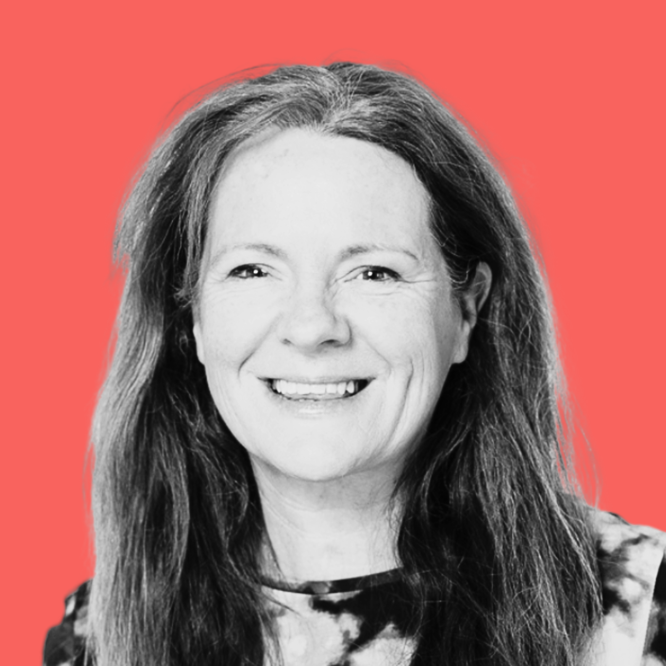 Black and white portrait of a smiling woman with long hair, set against a coral background.