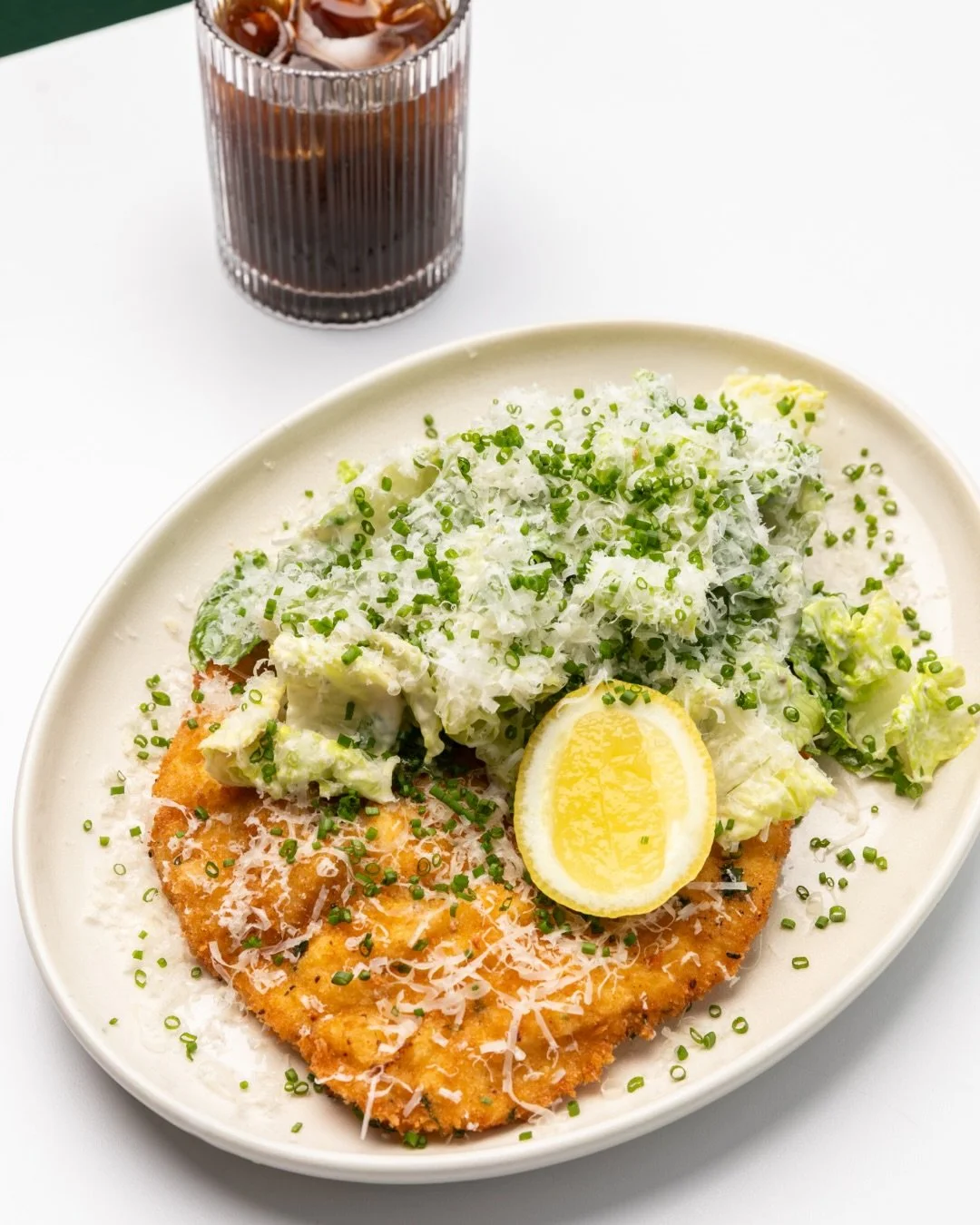 Golden, crispy and loaded: our house crumbed chicken schnitzel reinvents a classic, Friction style. 

With crisp cos lettuce, creamy Caesar dressing, shaved parmesan and fresh chives, it&rsquo;s crunchy, creamy and seriously satisfying.

Definitely t