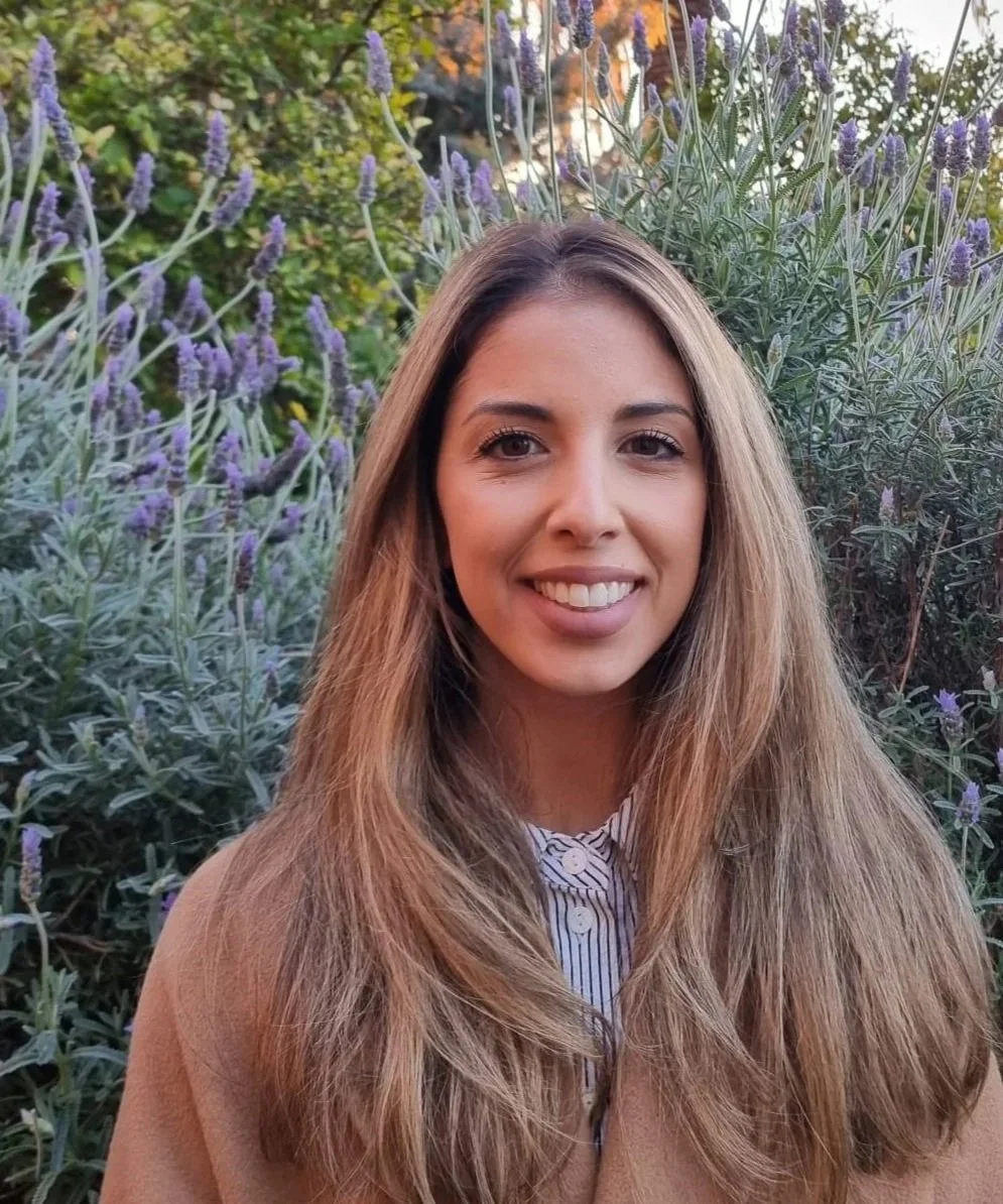 Emma, registered psychologist at Adsum Psychology in Thornbury, smiling in front of lavender