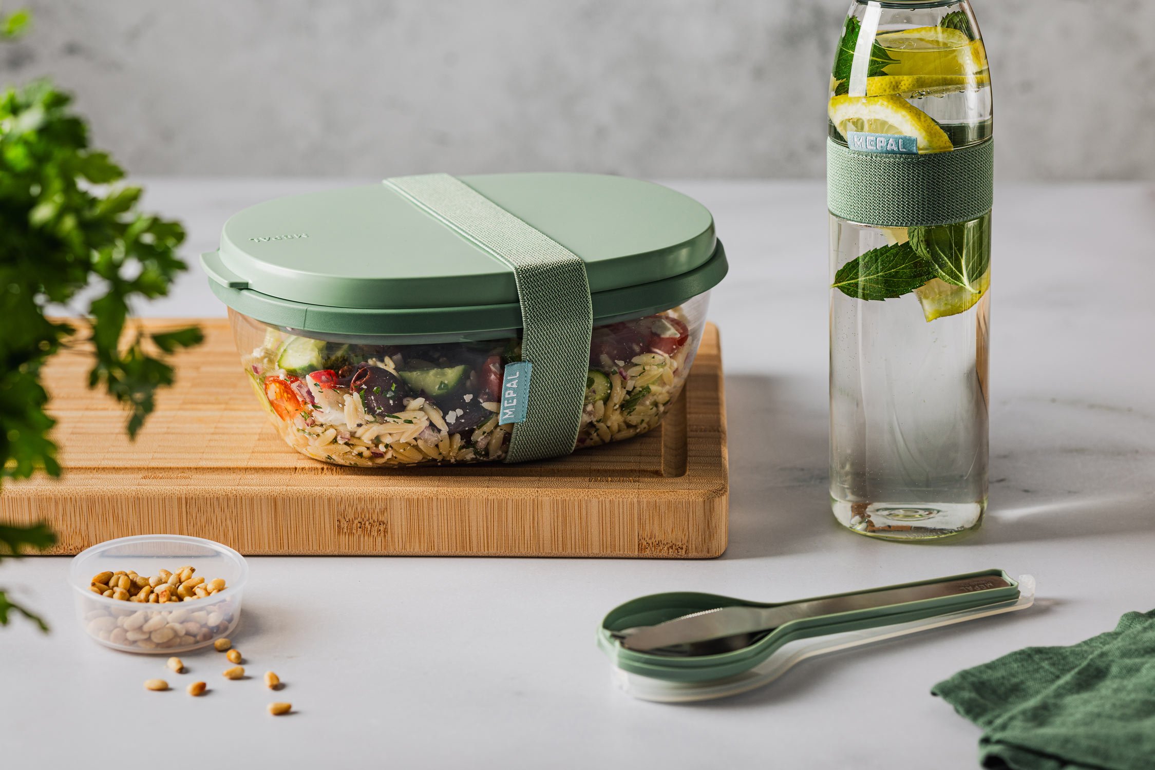 Mepal Lunchbox auf einem Holzbrett gefüllt mit einem mediterranen Orzo-Salat.