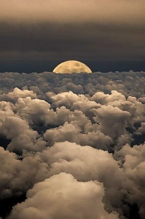 clouds with moon peaking out in the abck