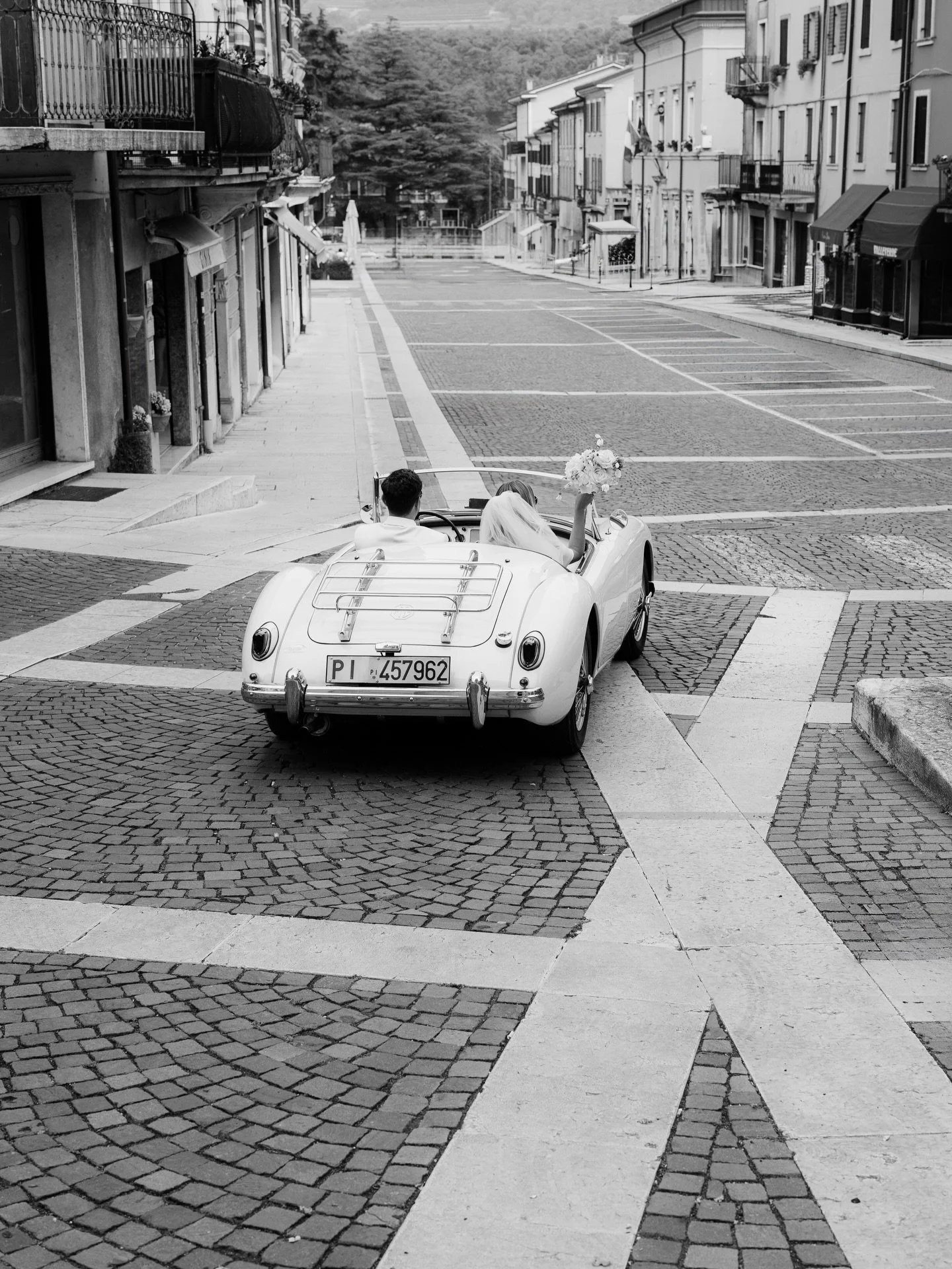 Just married. 🕊️ 
Driving through a small Italian village in a vintage MG, on their way to celebrate at Villa @mosconibertani 

#destinationweddingitaly #mosconibertani #veronawedding #vintagemg #melanienedelko