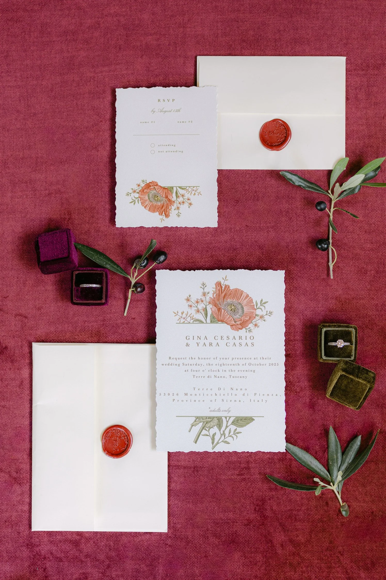 Elegant wedding invitation flatlay with white flowers, grapes, and rings
