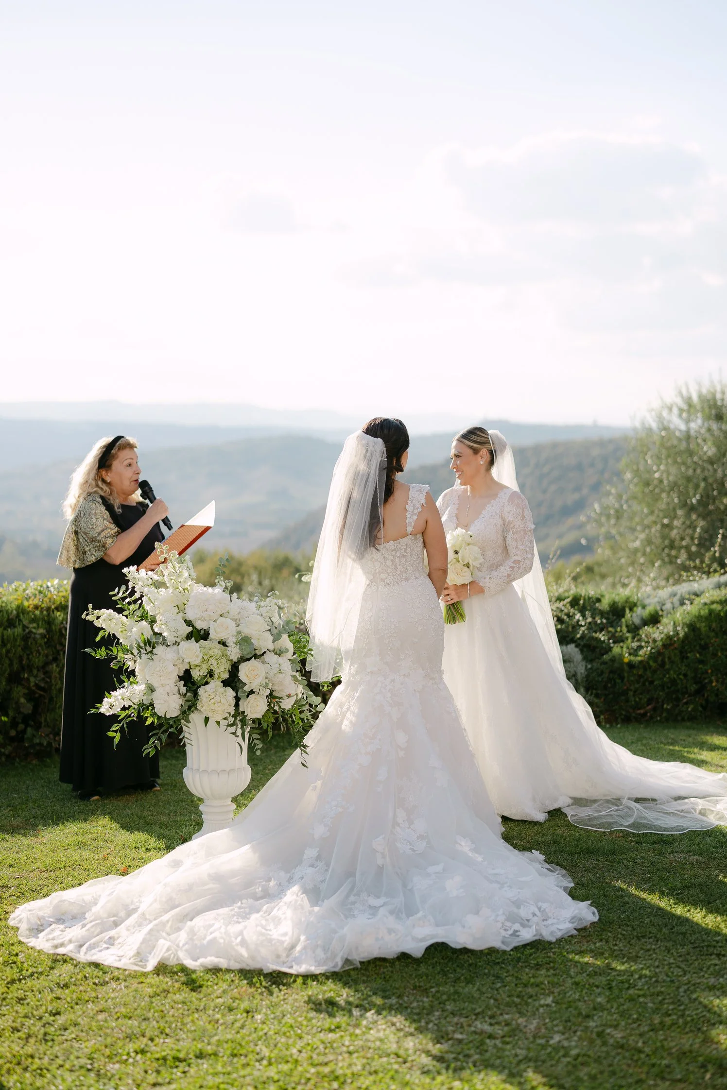 Two brides exchanging vows during a same-sex ceremony in Tuscany. Celebrant Tuscan Pledges, Venue Terre di Nano