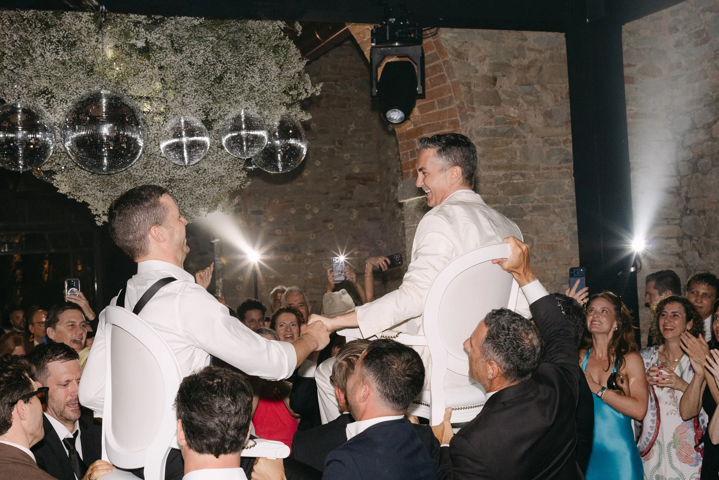 The couple lifted onto chairs during a traditional Jewish wedding celebration - Hora Dance 