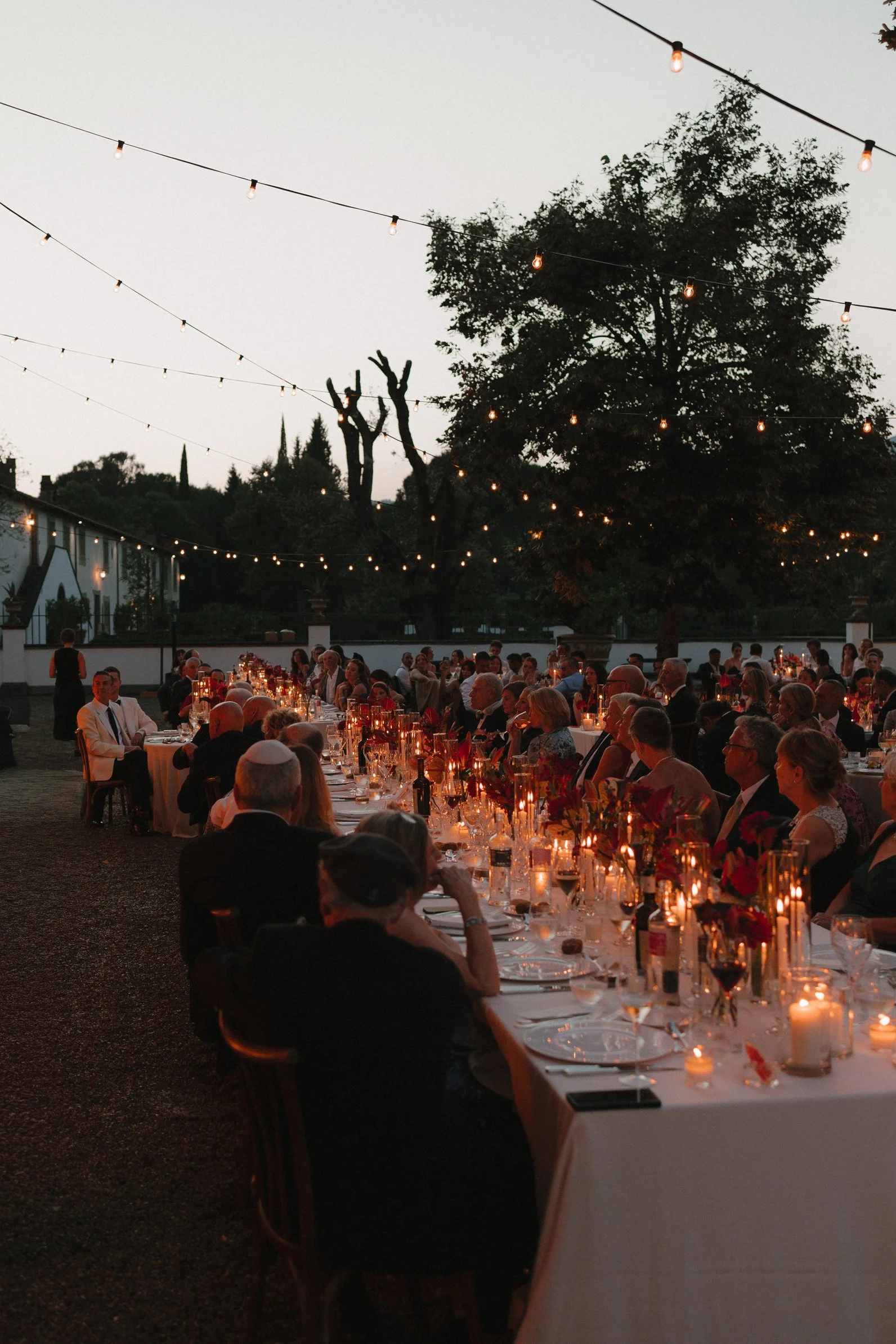 Outdoor wedding dinner beneath string lights at Il Borro