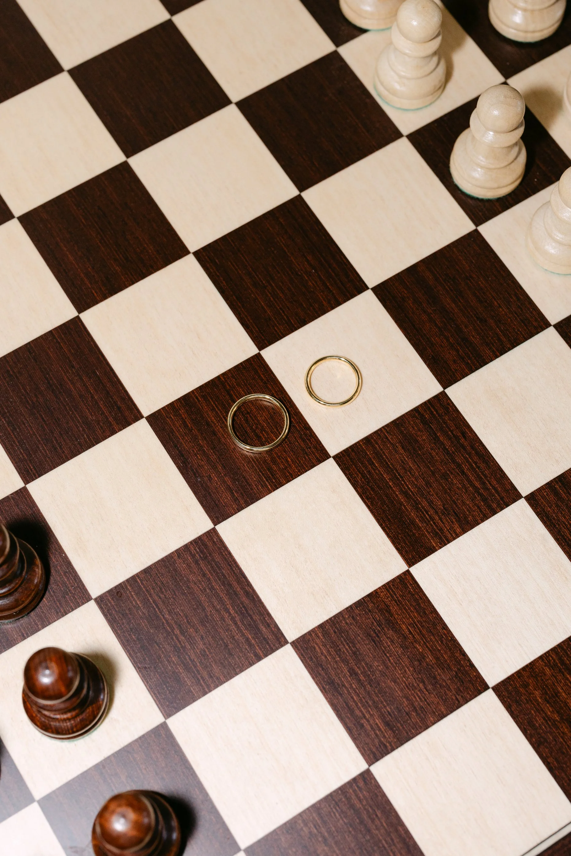 Wedding rings styled on a chess board at Il Borro