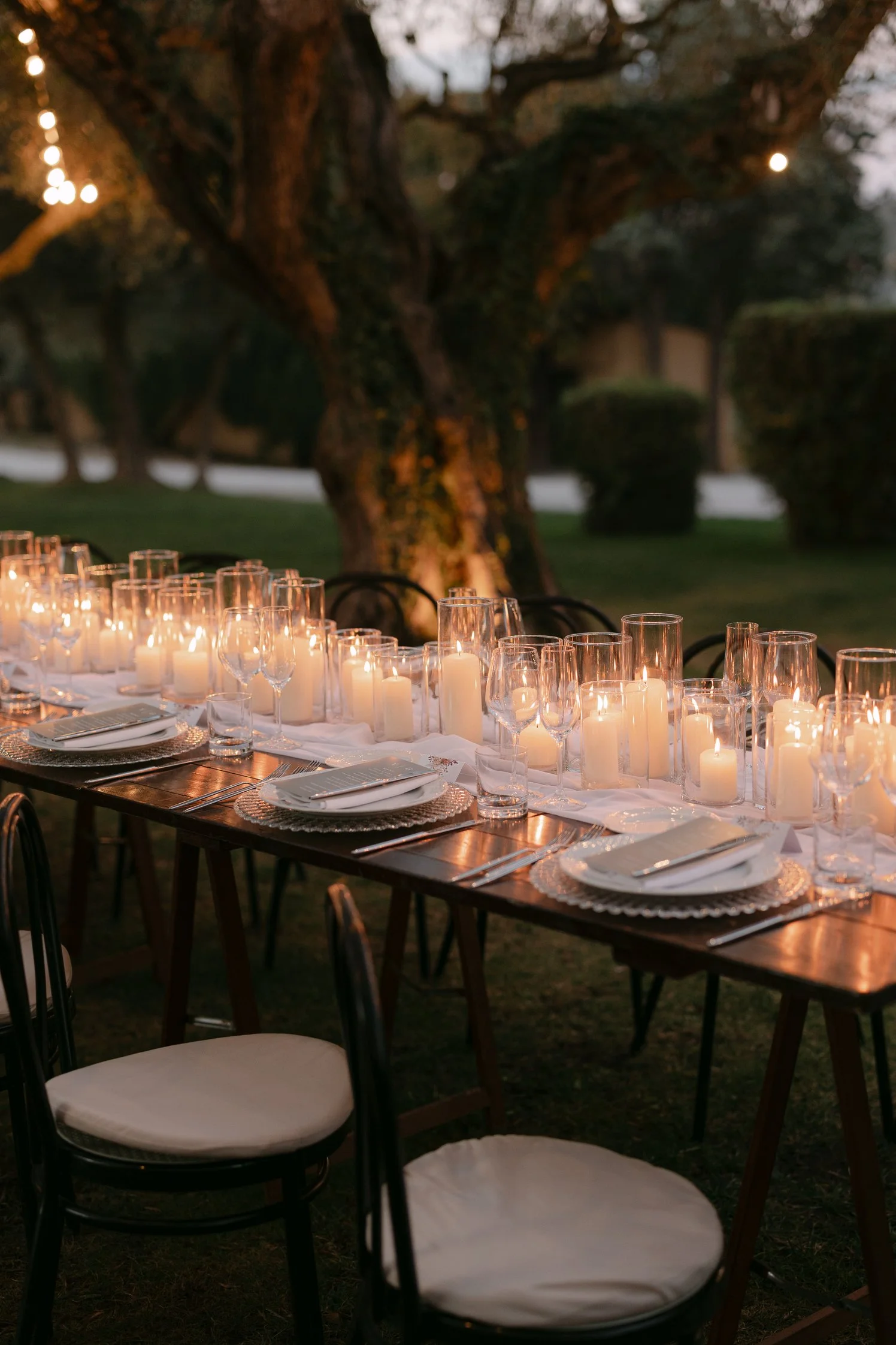 Close-up of glowing candles on an outdoor wedding table in Tuscany.