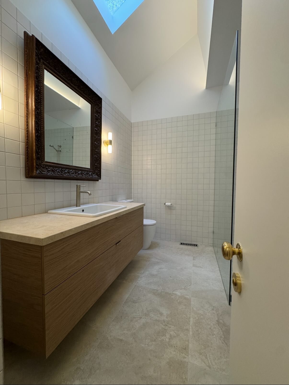 We said goodbye to these outdated terracotta tiles and gave this bathroom a complete makeover. 
Now featuring warm natural stone and soft lighting, this bathroom feels spacious, modern and elegant.