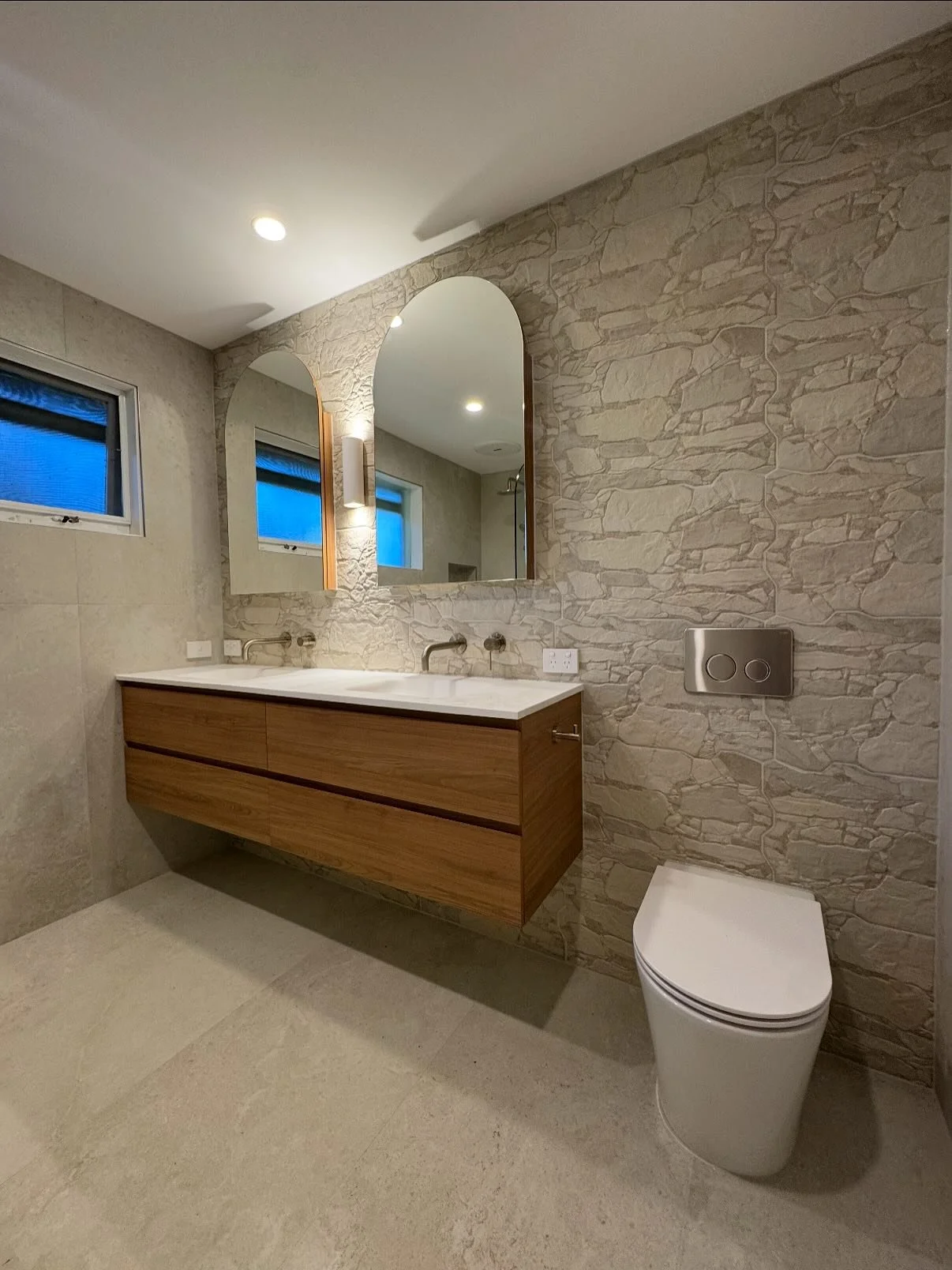 Swipe to see this stunning bathroom makeover featuring:

&bull; Walk-in shower with rainfall head
&bull; Custom floating vanity with twin sinks
&bull; Natural stone textures &amp; soft lighting
&bull; Sleek brushed nickel tapware

#BathroomRenovation