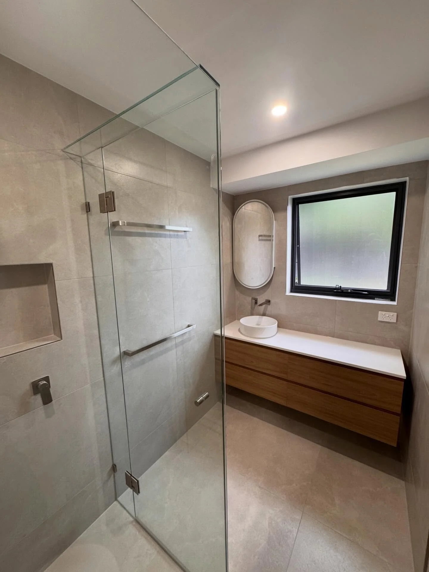 A refined and contemporary ensuite renovation in Langwarrin.

This space was designed with a focus on clean detailing, balanced proportions, and long-term functionality. 

Neutral porcelain tiles are complemented by a custom floating timber vanity, s