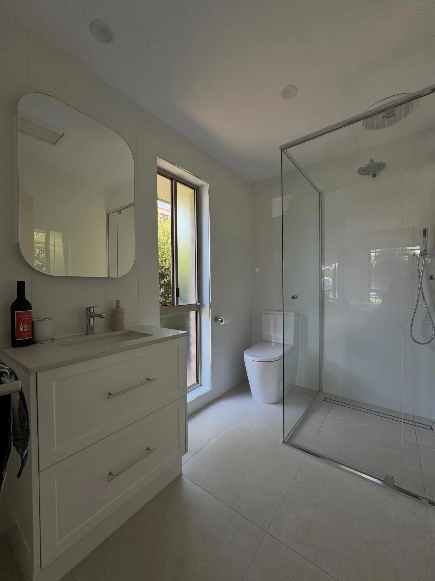 A clean, bright and timeless ensuite renovation completed in Safety Beach.

This space was designed to maximise natural light while keeping a simple, modern feel. 
The large format tiles, semi frameless glass shower and custom vanity create a fresh a