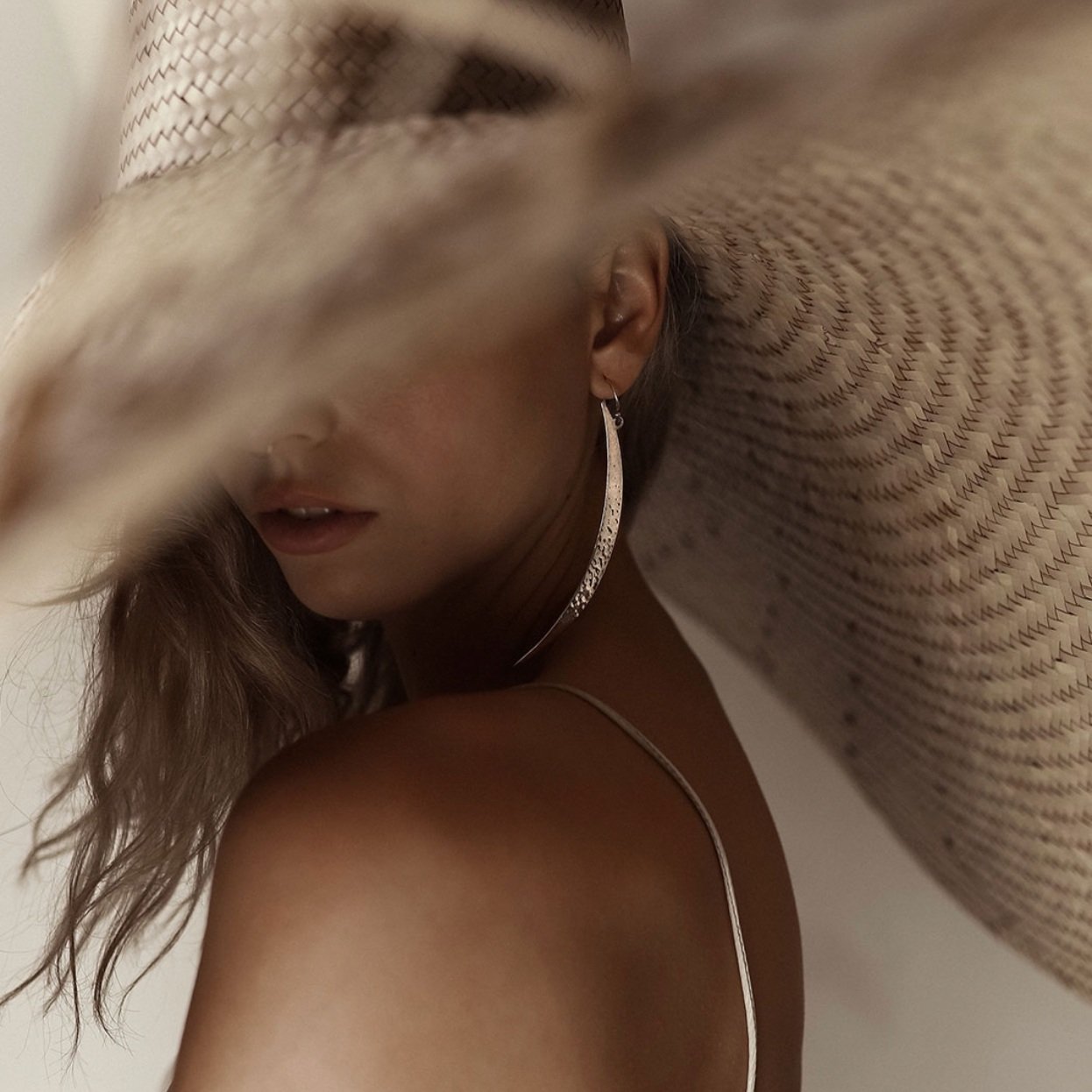 Donna con cappello di paglia e orecchino lungo
