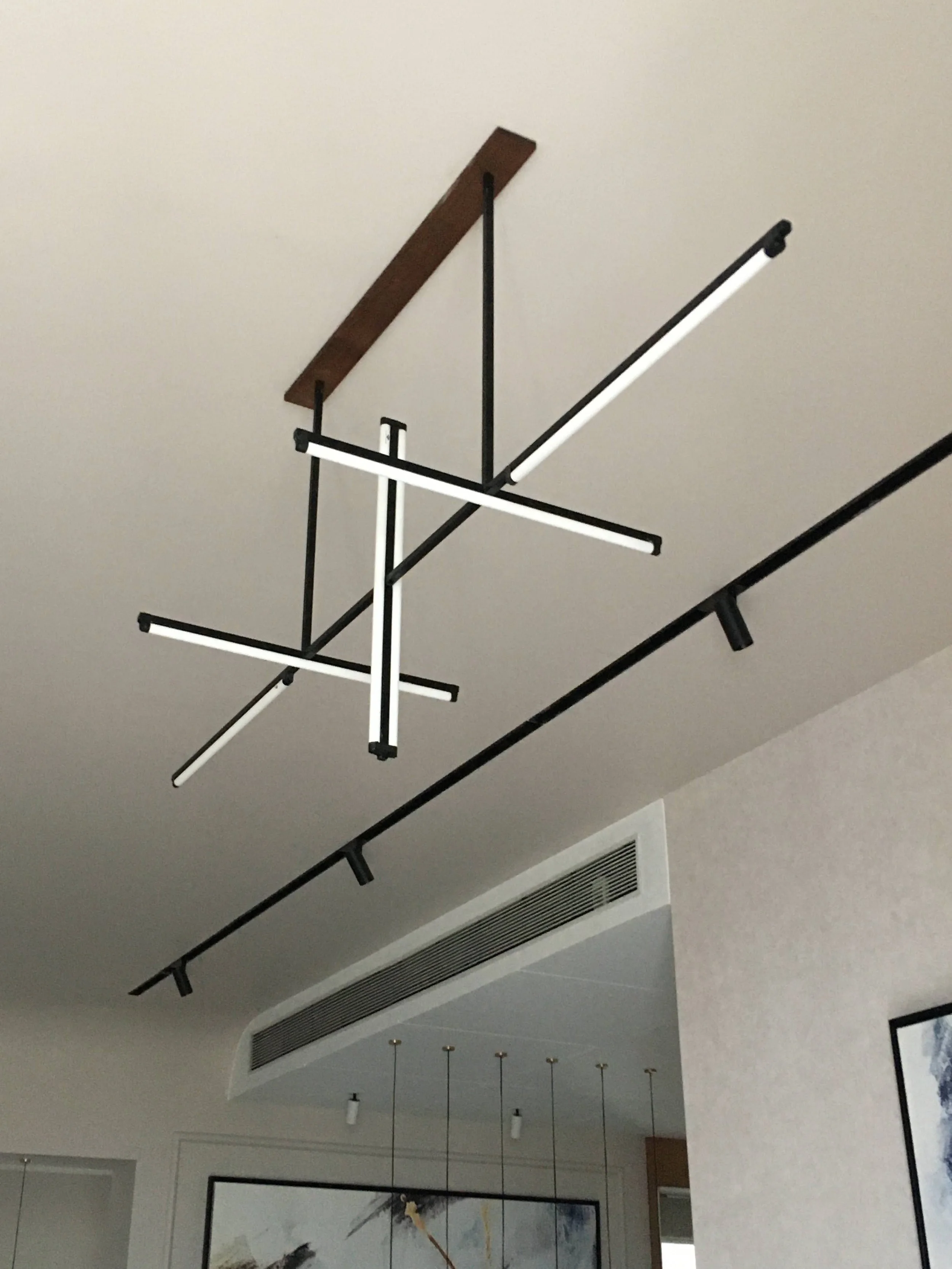 Modern geometric ceiling light fixture with intersecting black and white bars