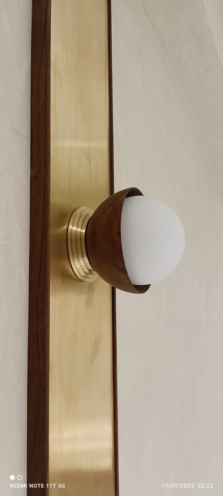 Wall-mounted light fixture with a metallic and wooden design