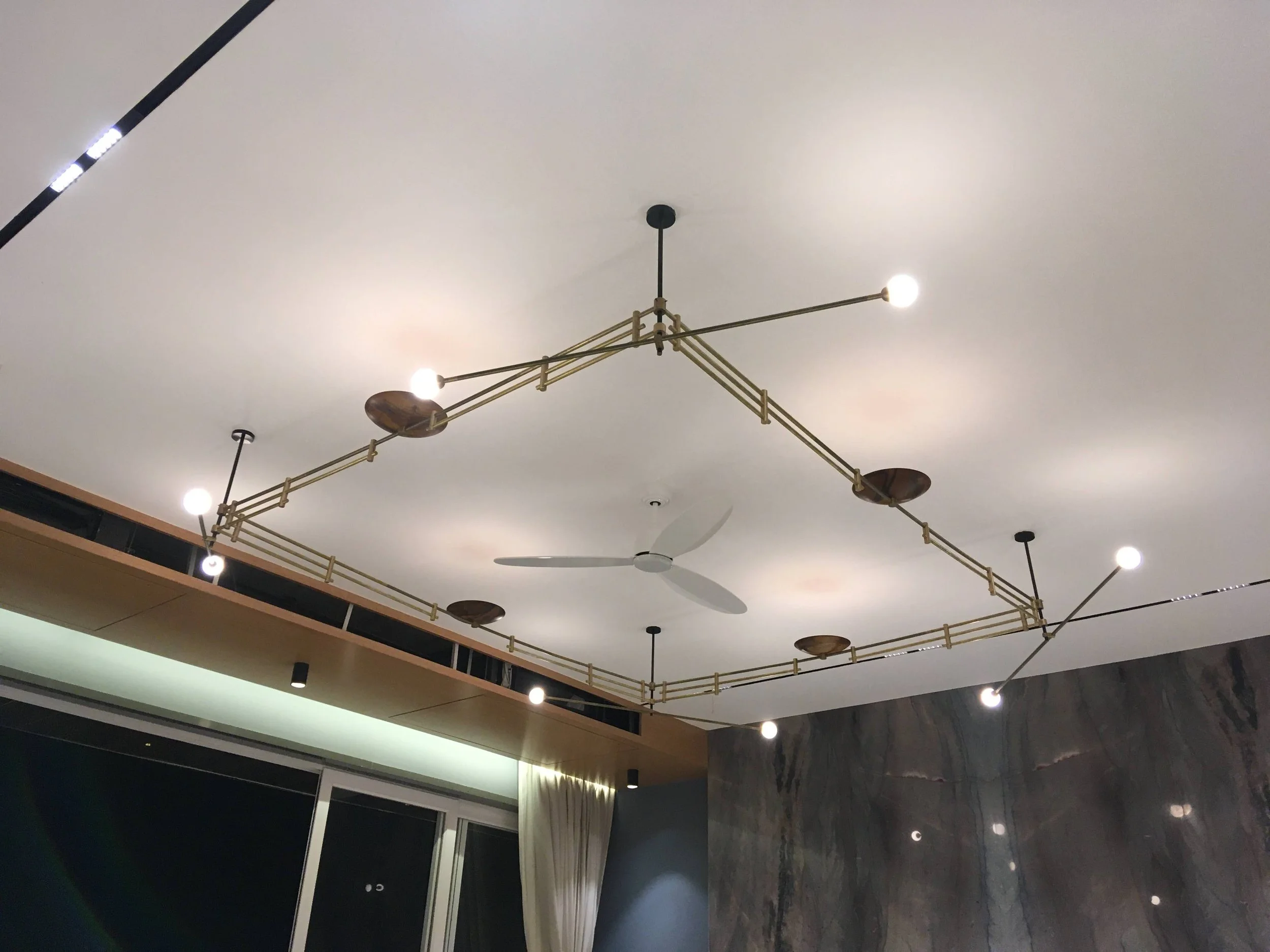 Modern ceiling with brass light fixture and fan