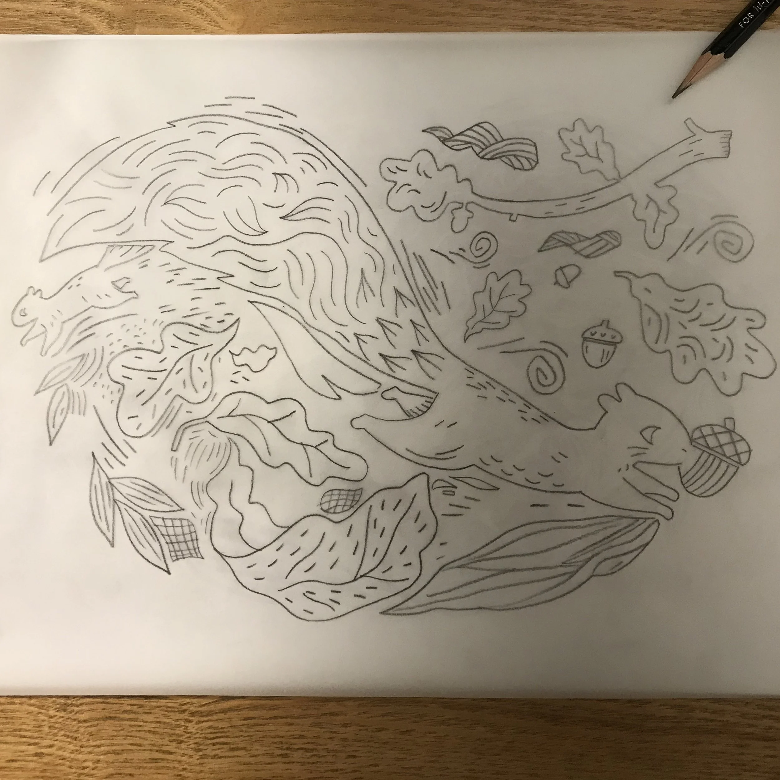 Black and white line drawing of a whimsical mermaid with wavy hair, surrounded by autumn leaves, acorns, and swirls on a white sheet of paper placed on a wooden surface.