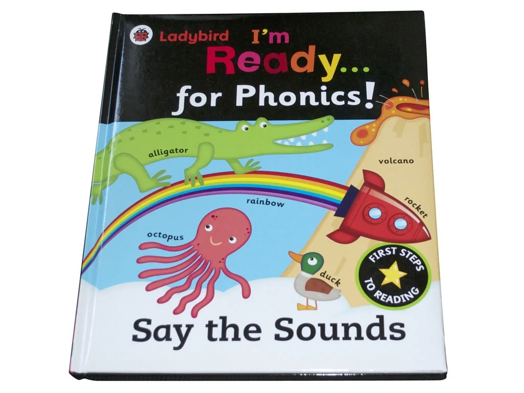 Colorful children's book titled "I'm Ready... for Phonics!" featuring illustrations of an alligator, octopus, rainbow, volcano, rocket, and duck, with labels for each.