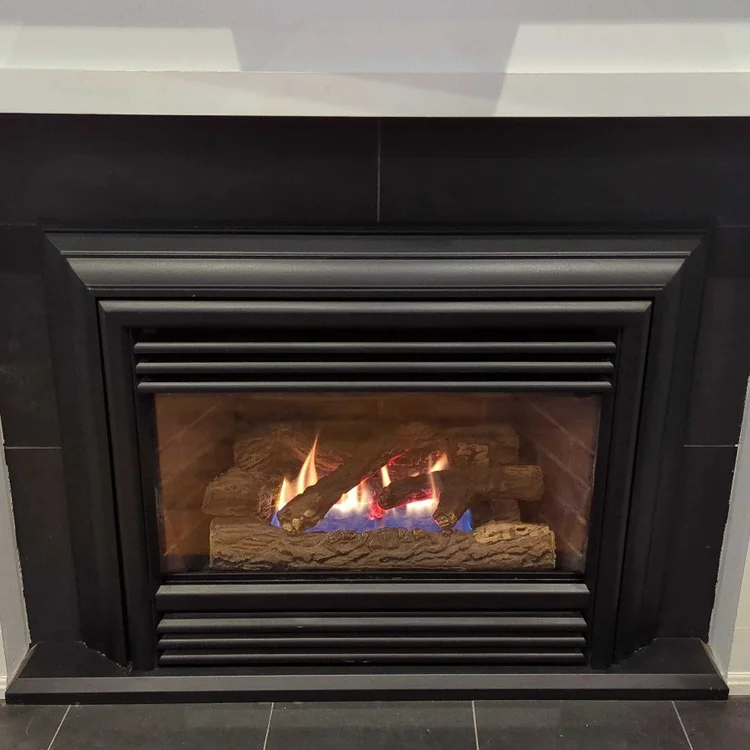 Gas fireplace insert with black tile surround and white mantel, after cleaning
