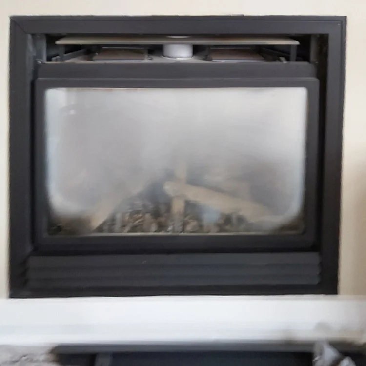 Gas fireplace in a beige wall, before cleaning