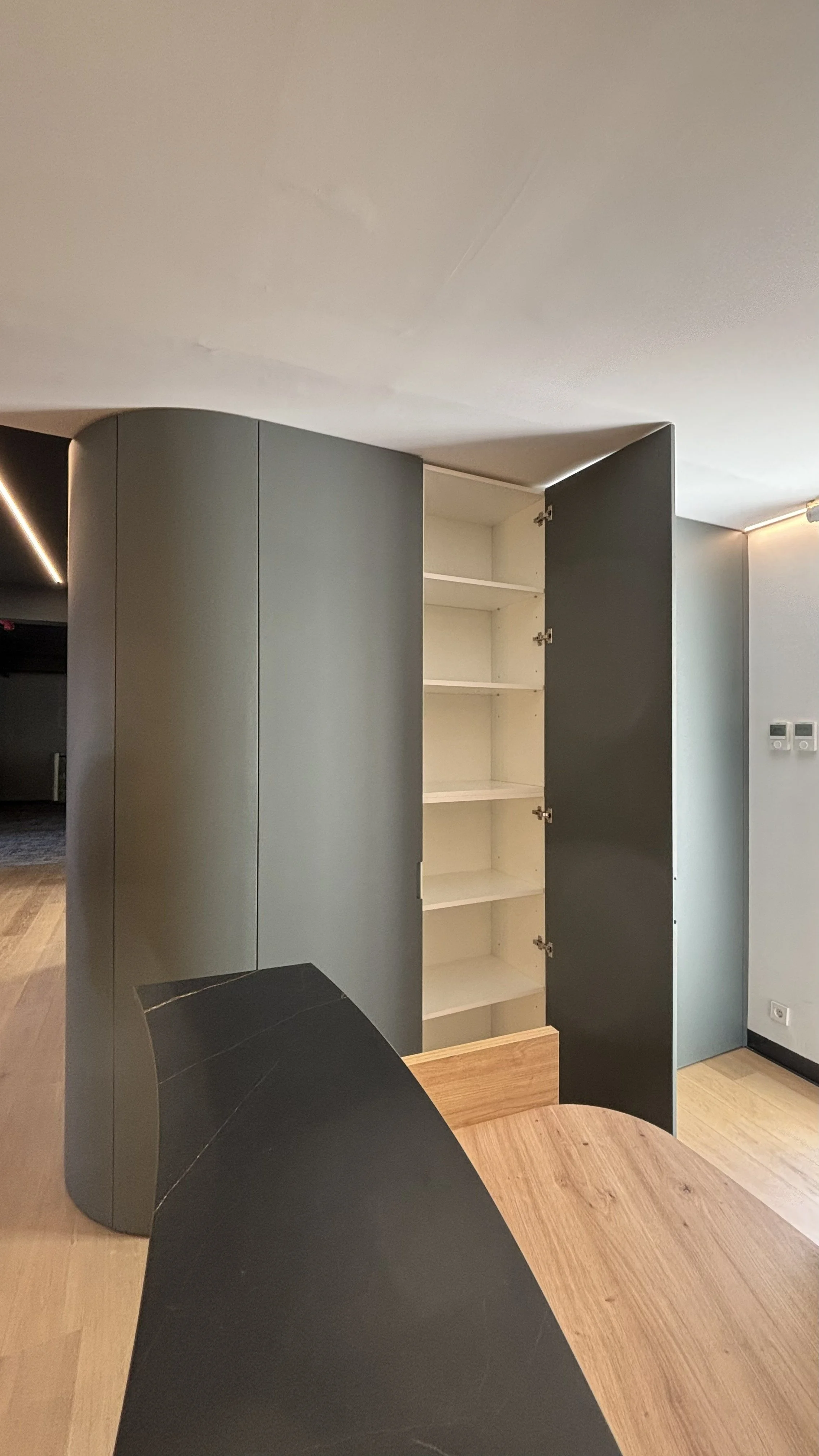 Armario de diseño moderno con puertas abiertas, mostrando estantes blancos en su interior.