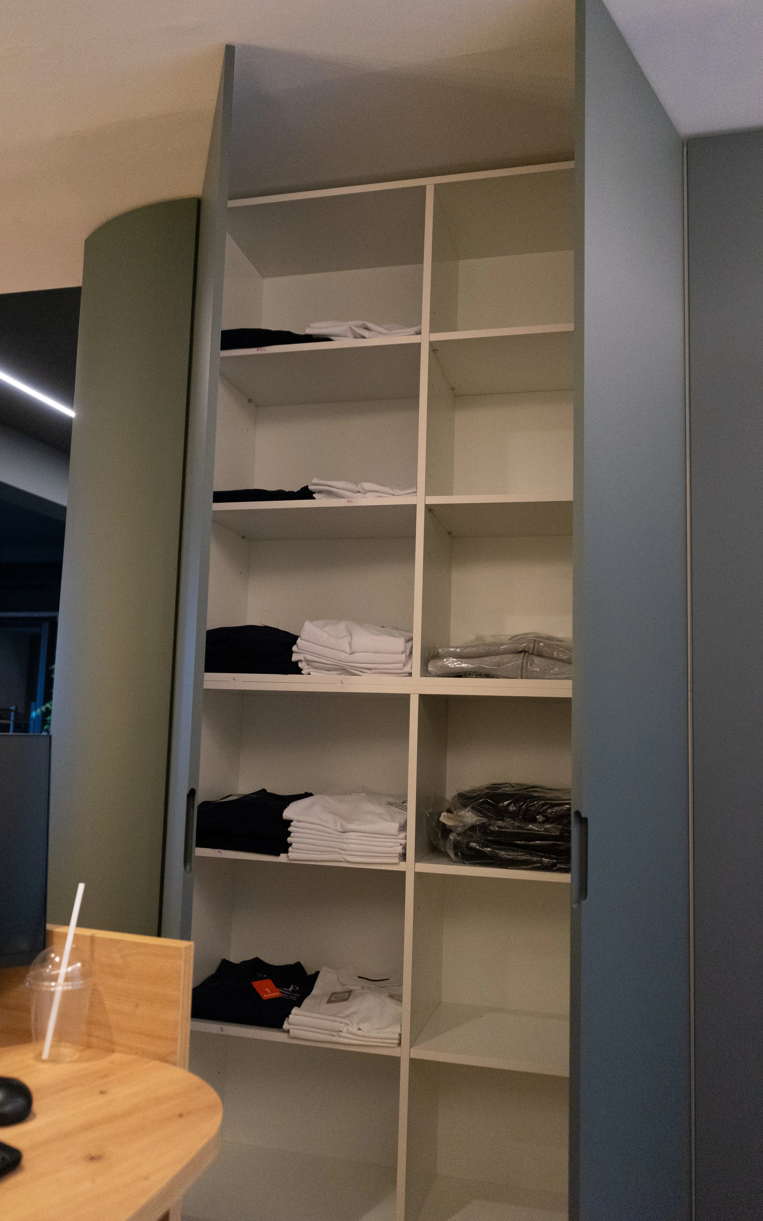 Estantería con ropa doblada y empaquetada, en un ambiente interior.