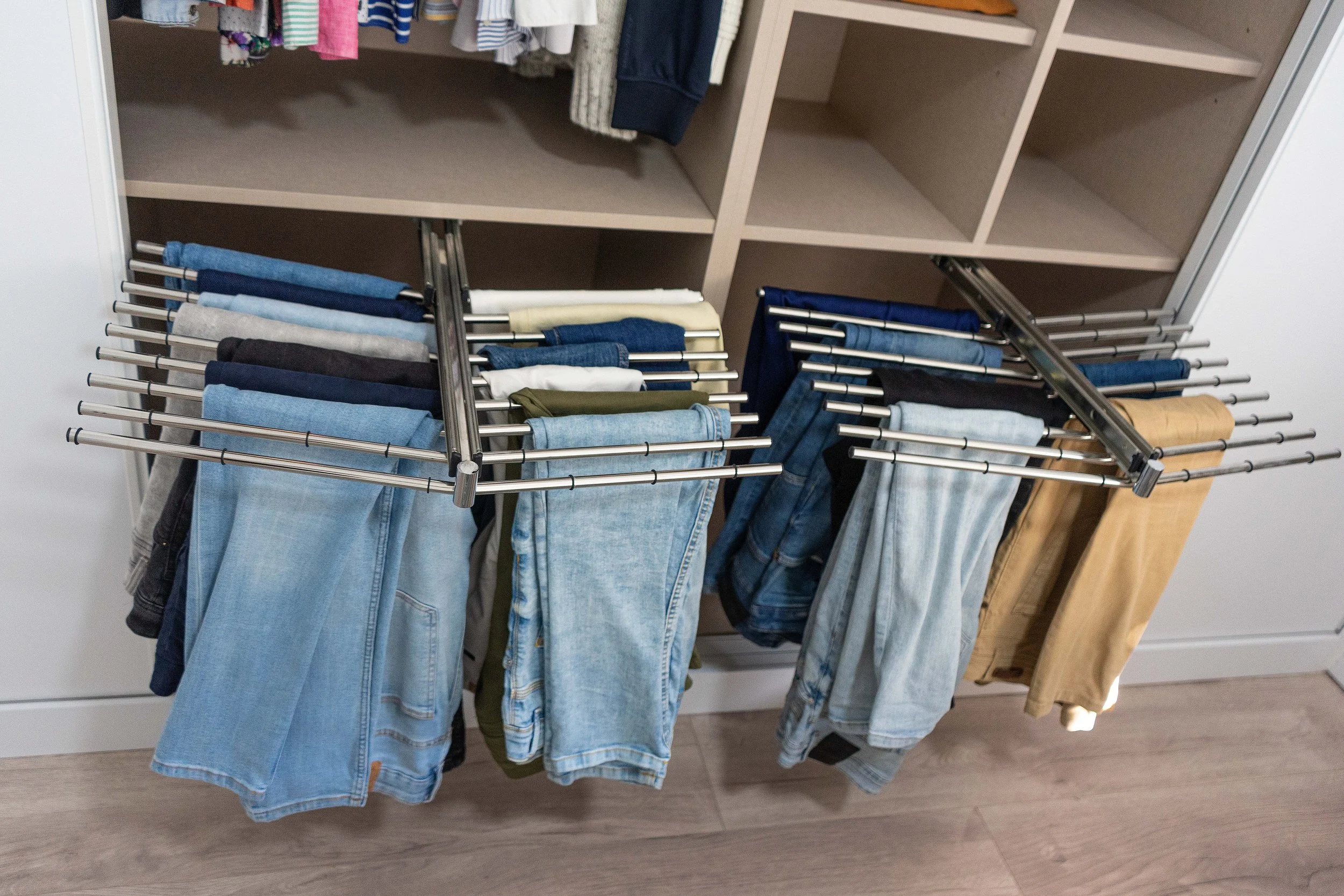 Ropa de mezclilla y pantalones colgados en un tendedero en un armario.