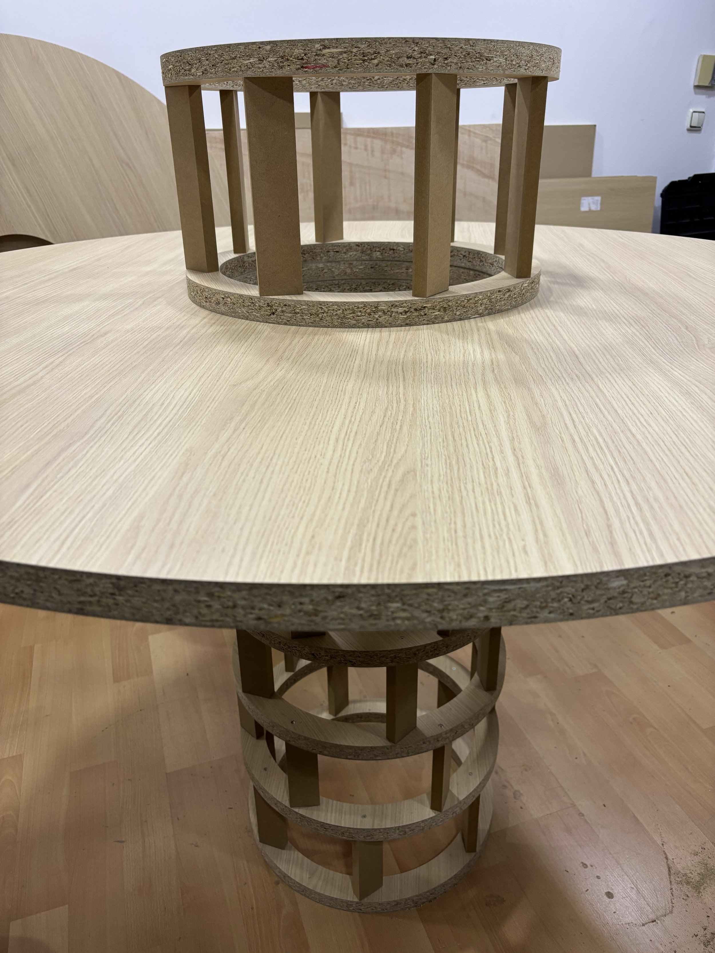 Mesa de madera con estructura interna de madera contrachapada y superficies de madera de color claro, vista desde arriba.