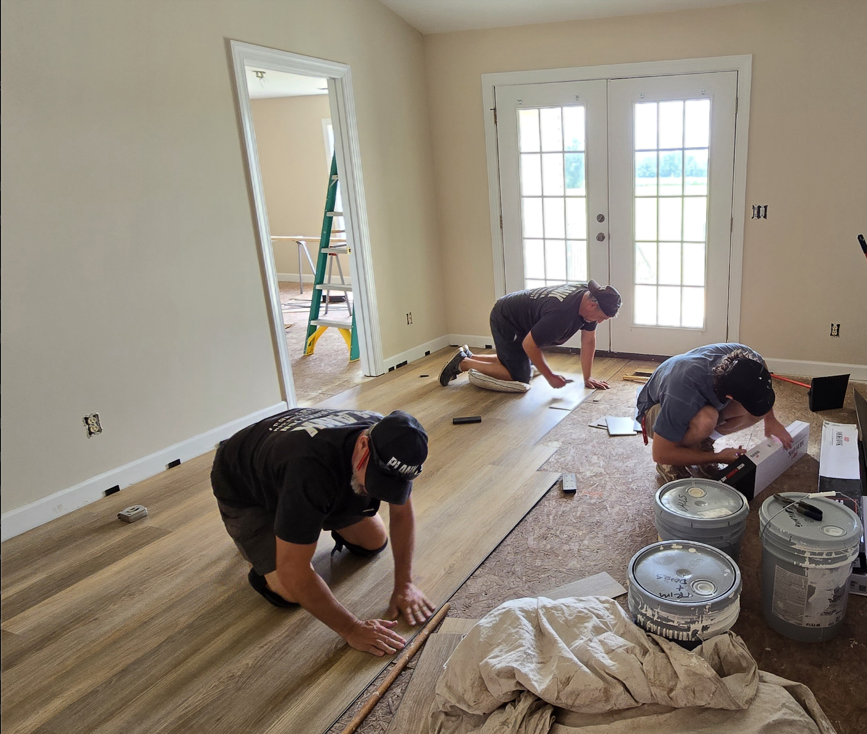 Plank Construction team laying down new hardwood flooring in residential home