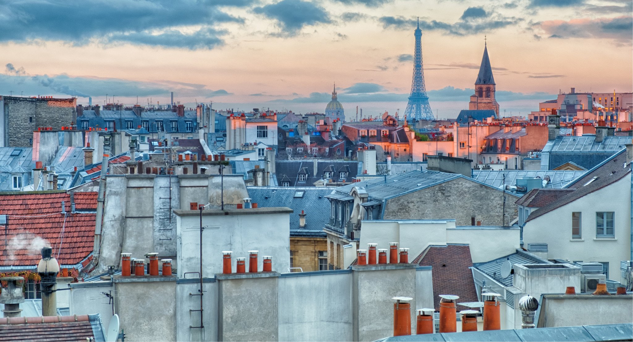   Catching the sunrise over Paris' rooftop mosaic with the Eiffel Tower emerging in the distance  