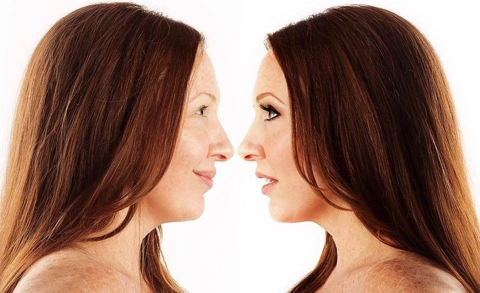 Two women with red hair facing each other in close-up portrait against a white background.
