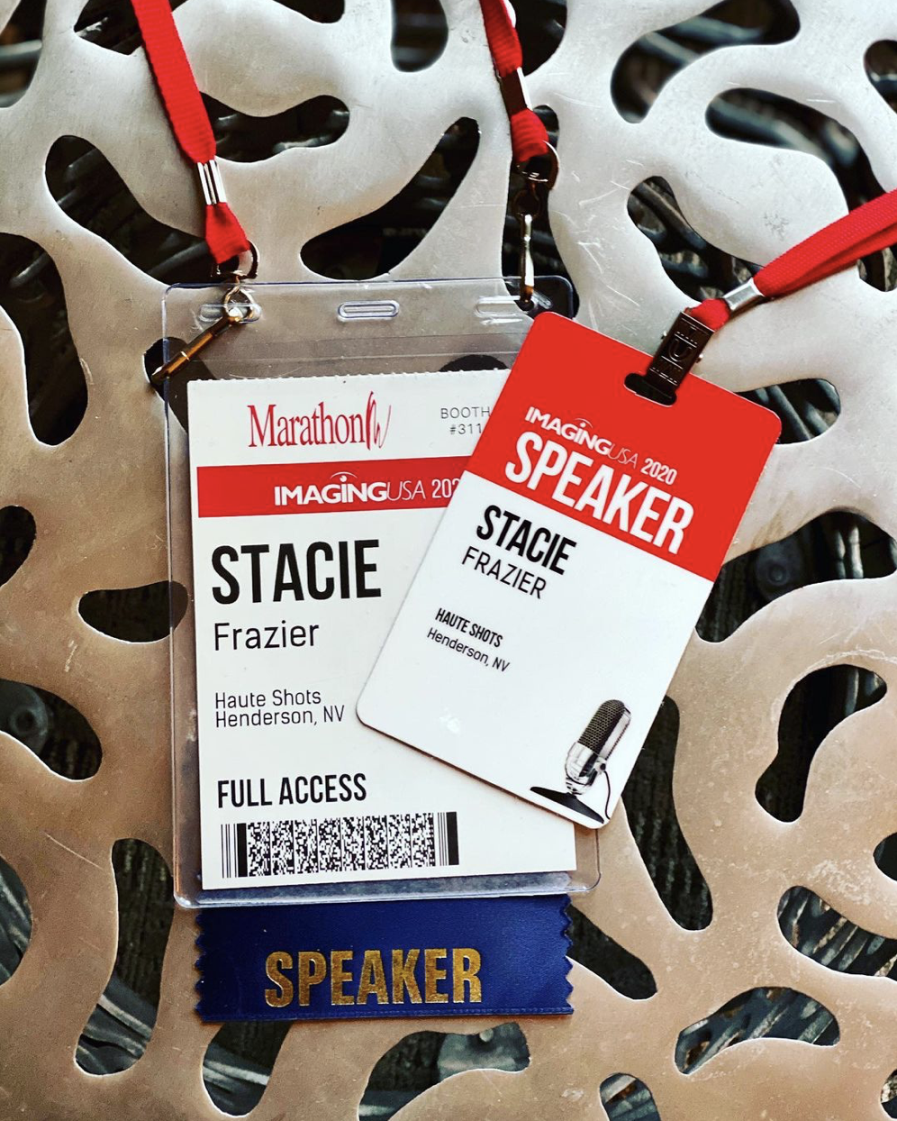 Conference badge and credential with two lanyards and a blue ribbon labeled "SPEAKER" attached to a decorative metallic background