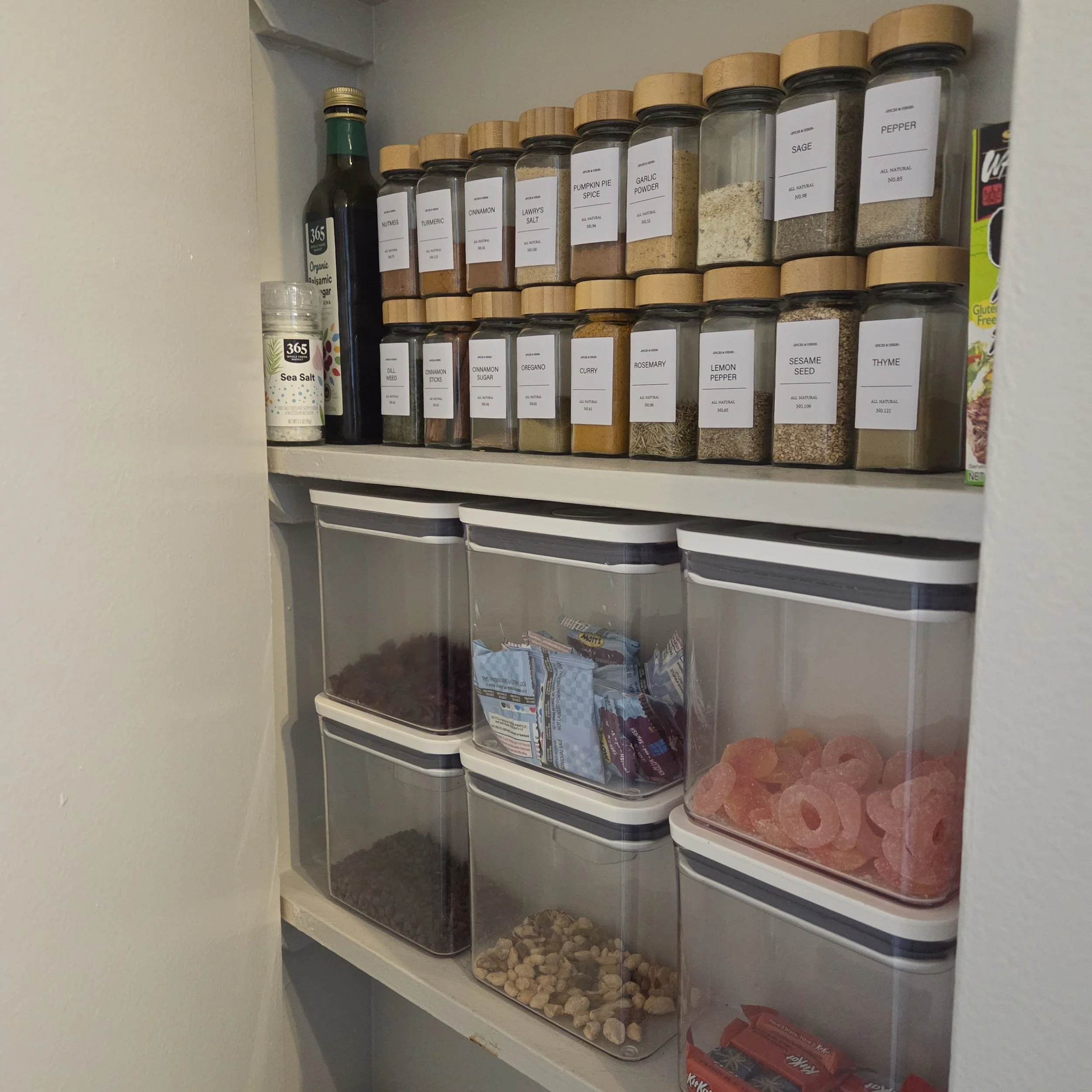 An image of an organized pantry with  jars and boxes of food stored