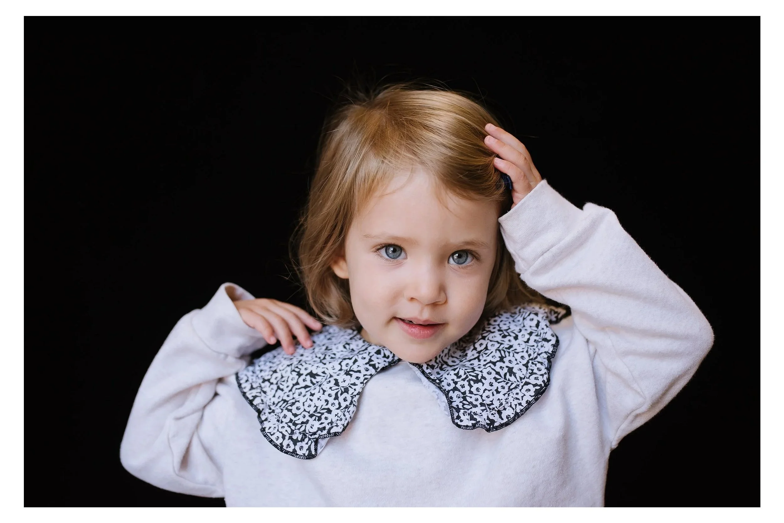 San Francisco Preschool portrait of child touching her hair bow